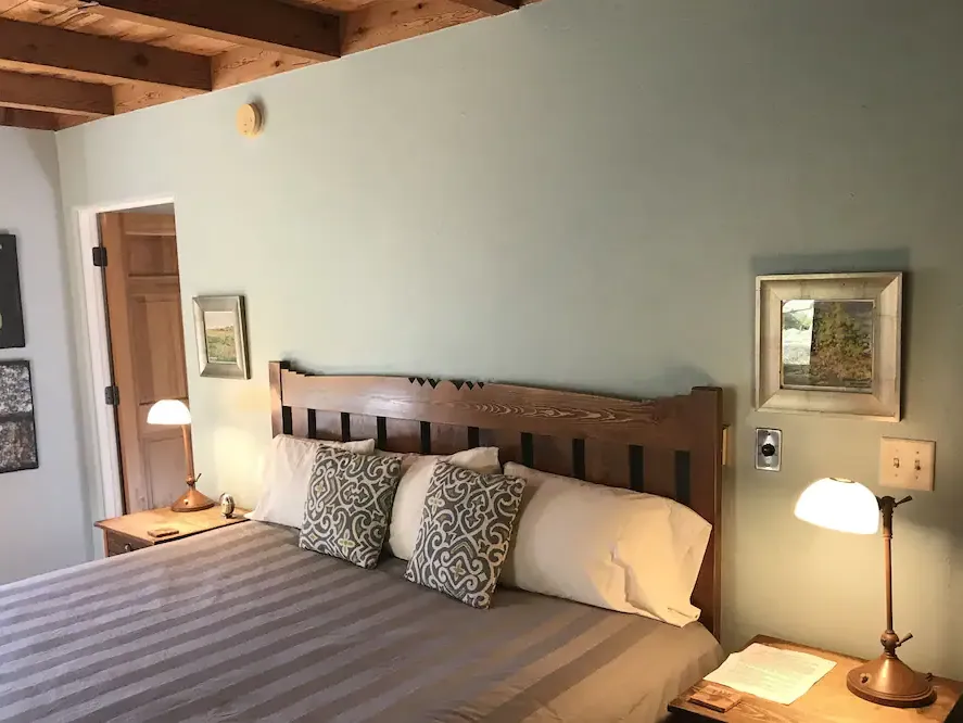 a bedroom with a bed , two nightstands , two lamps and a door .