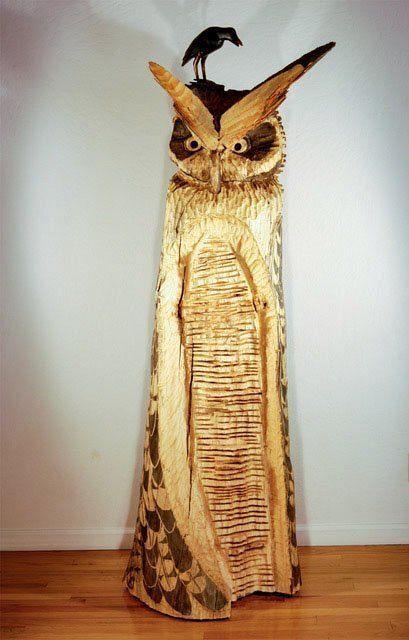 A statue of an owl with a bird on its head
