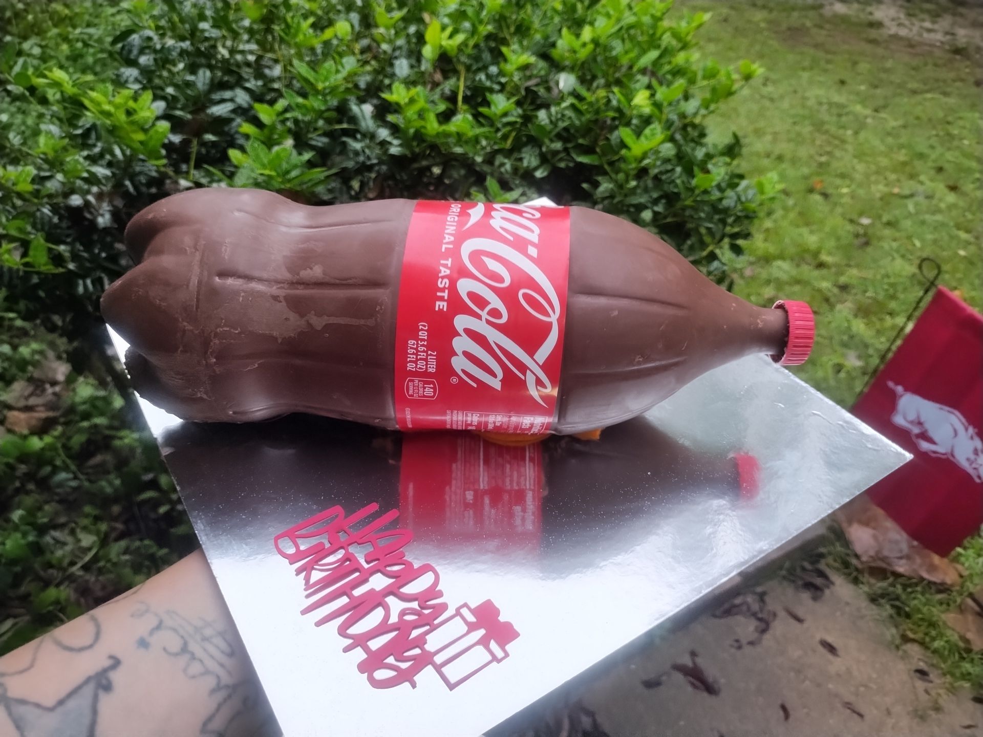Chocolate Coca-Cola bottle cake on silver board with 