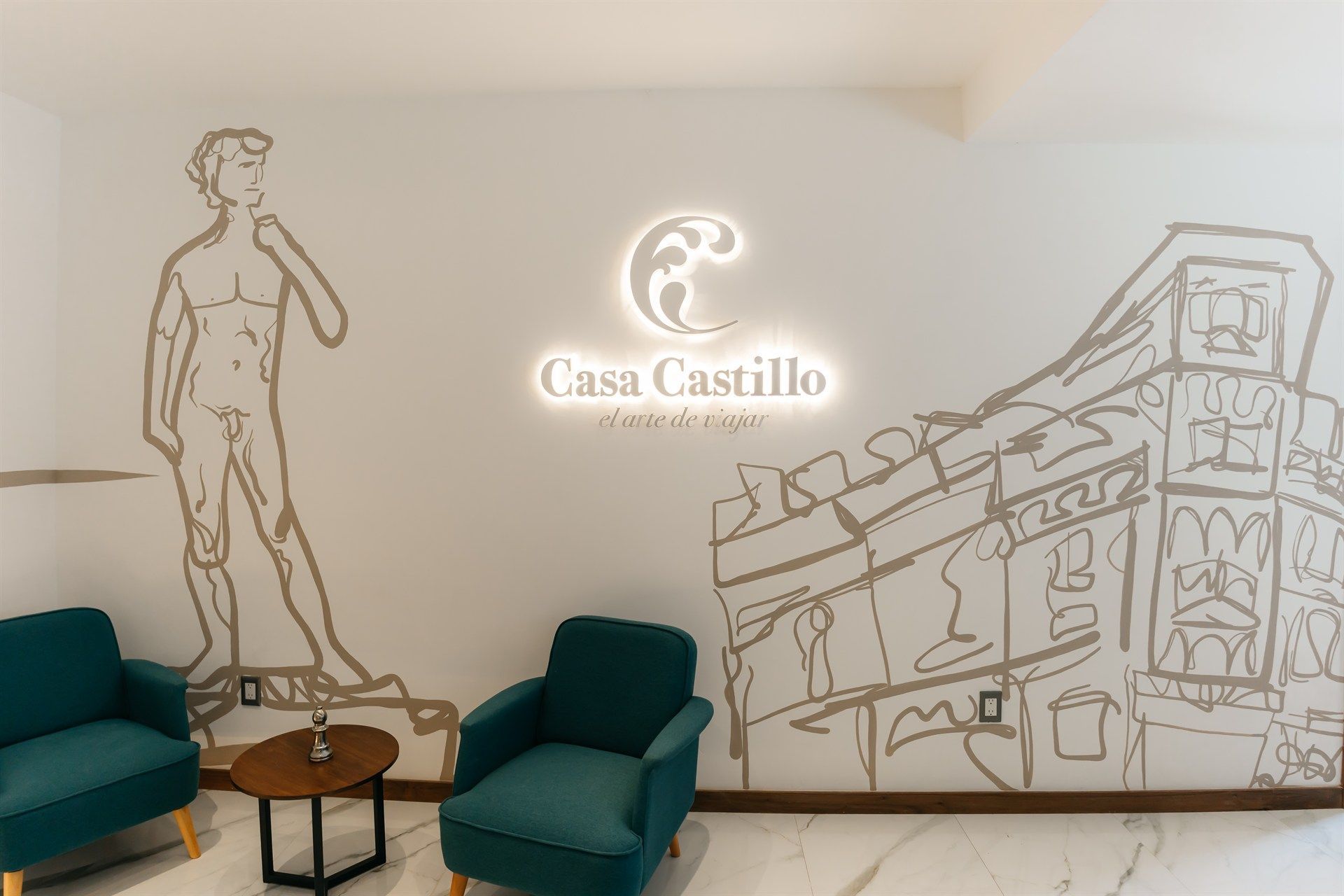 A room with chairs and a table with a drawing of a man on the wall.