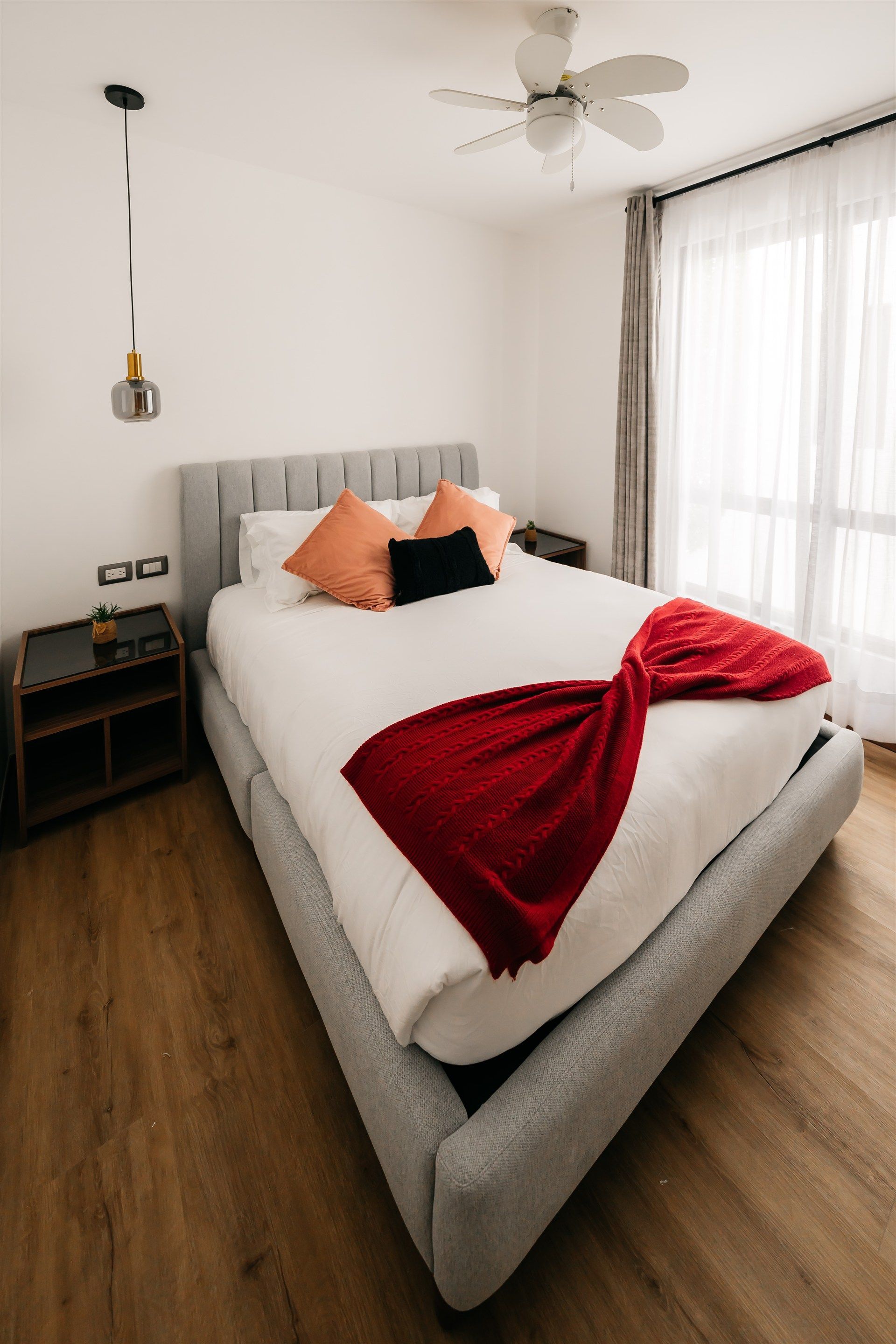 Un dormitorio con una cama grande y un ventilador de techo.