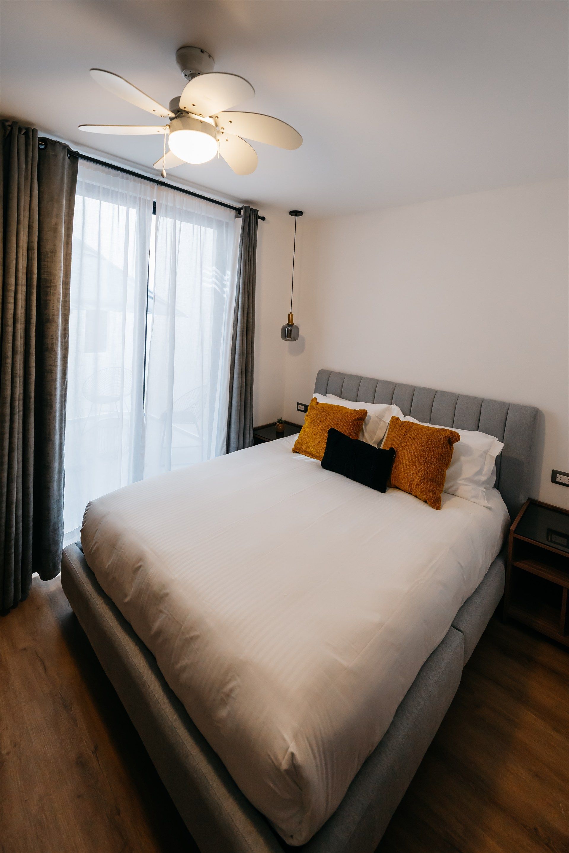 Un dormitorio con una cama grande y un ventilador de techo.