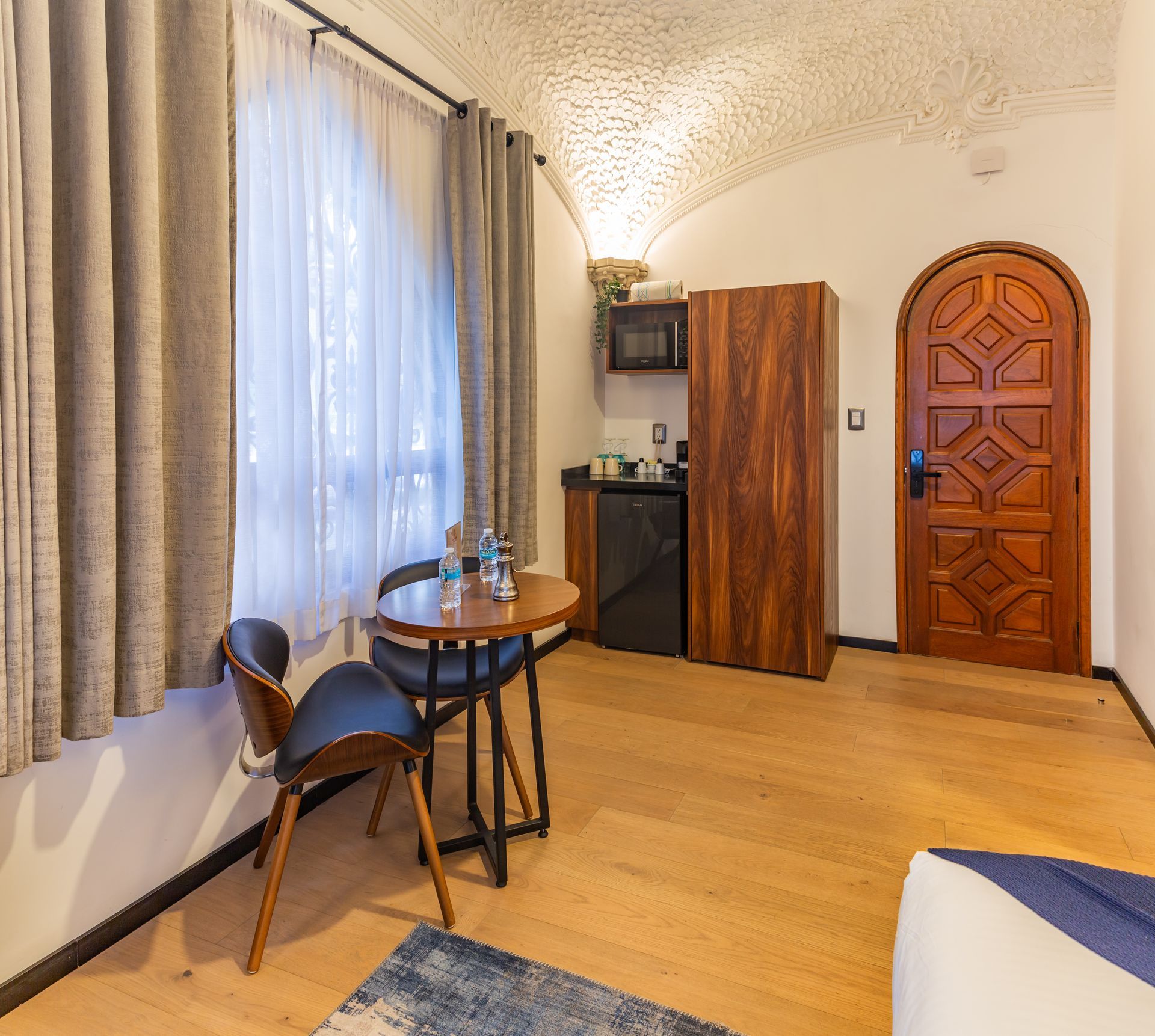 A hotel room with a table and chairs in it