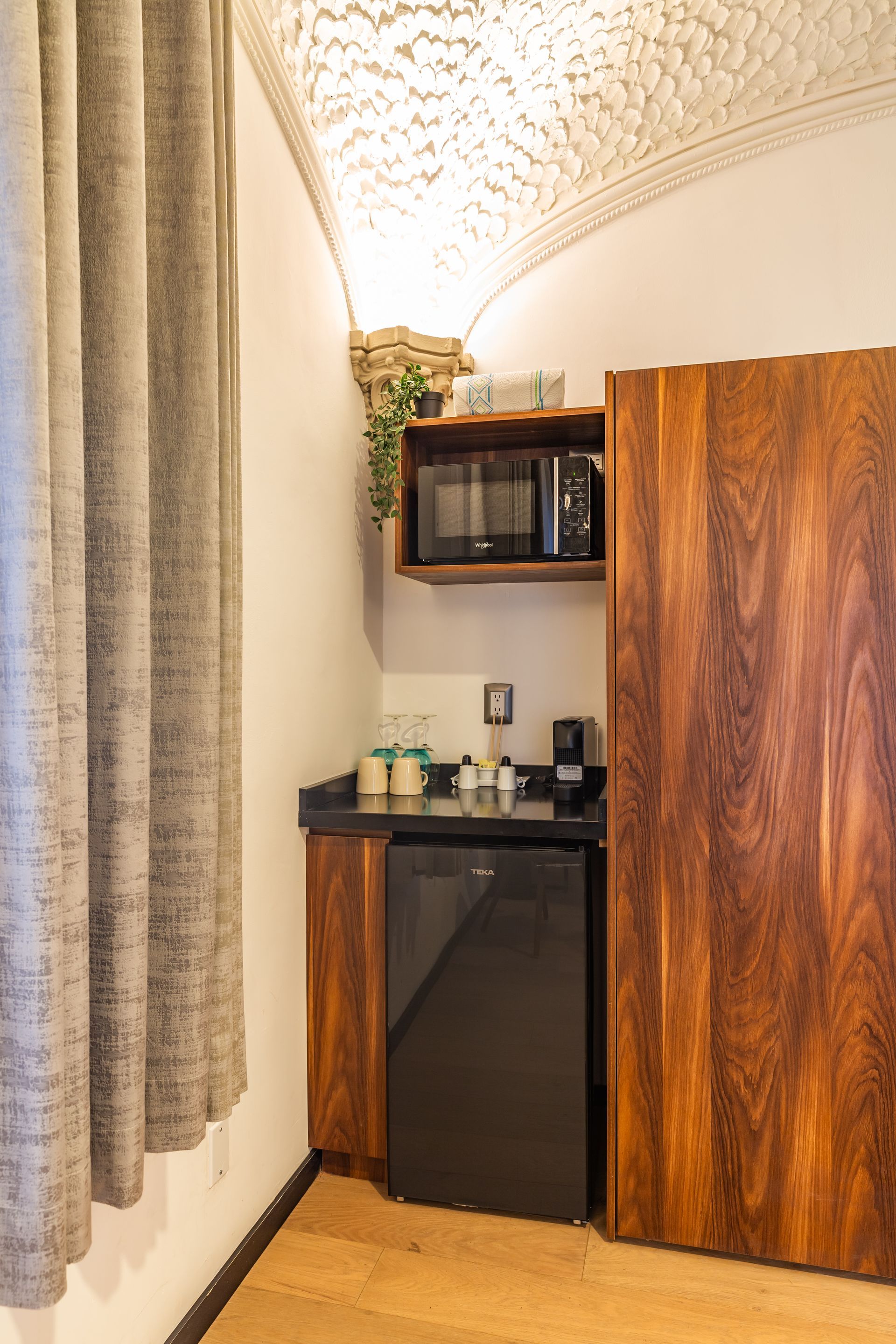 A kitchen with a refrigerator , microwave , and coffee maker.
