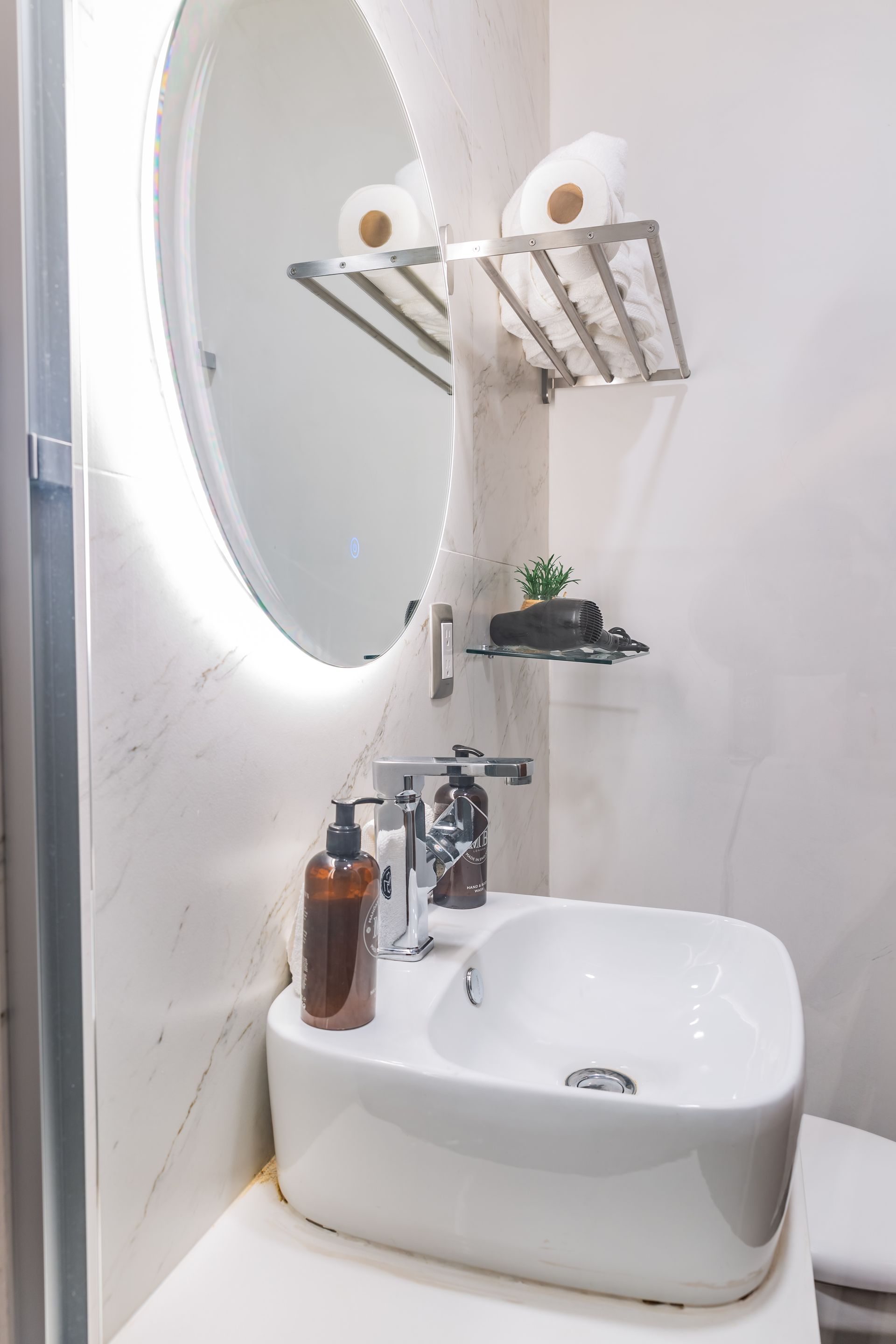 A bathroom with a sink , toilet and mirror.