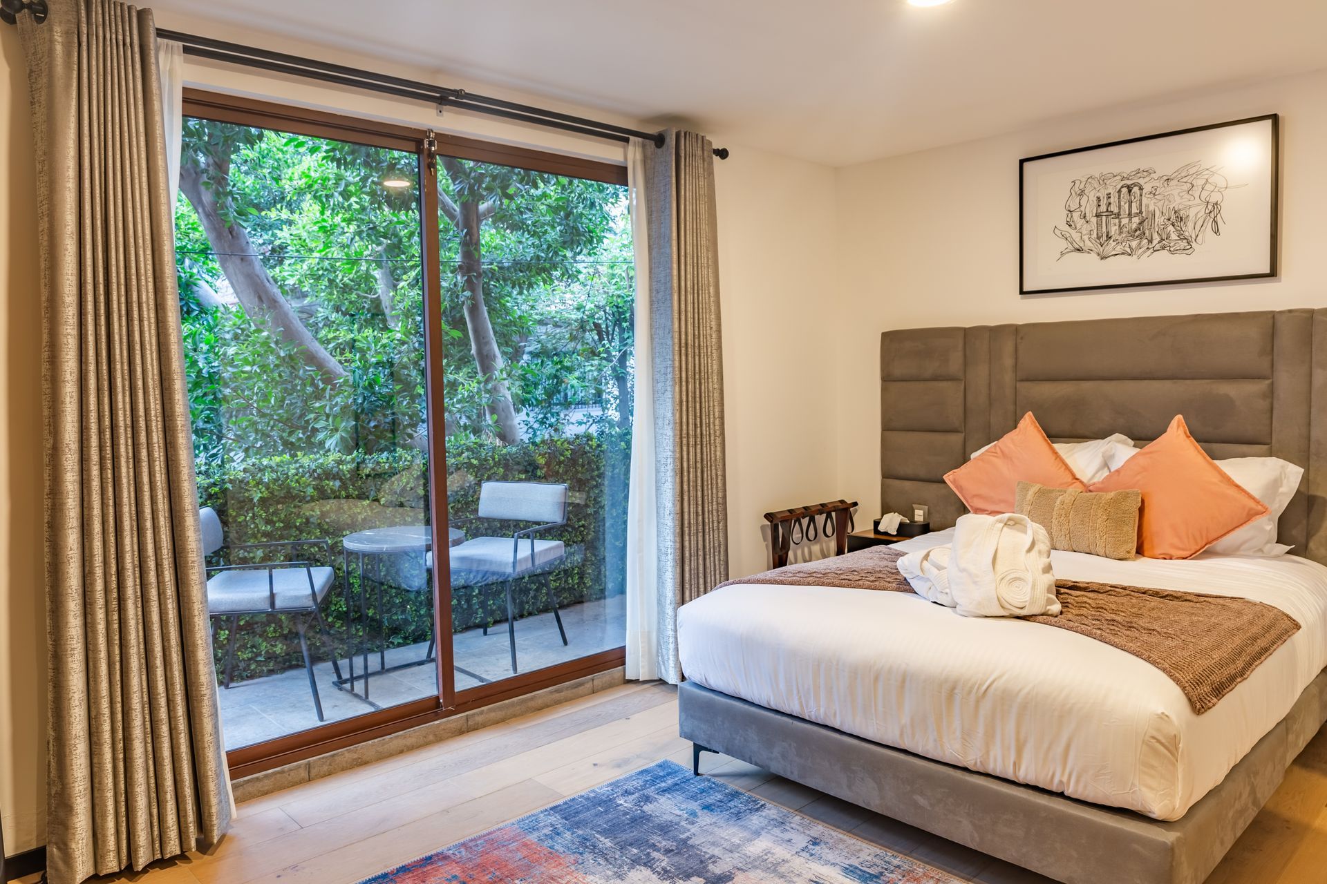 Un dormitorio con una cama tamaño king y una puerta corrediza de vidrio que conduce a un balcón.