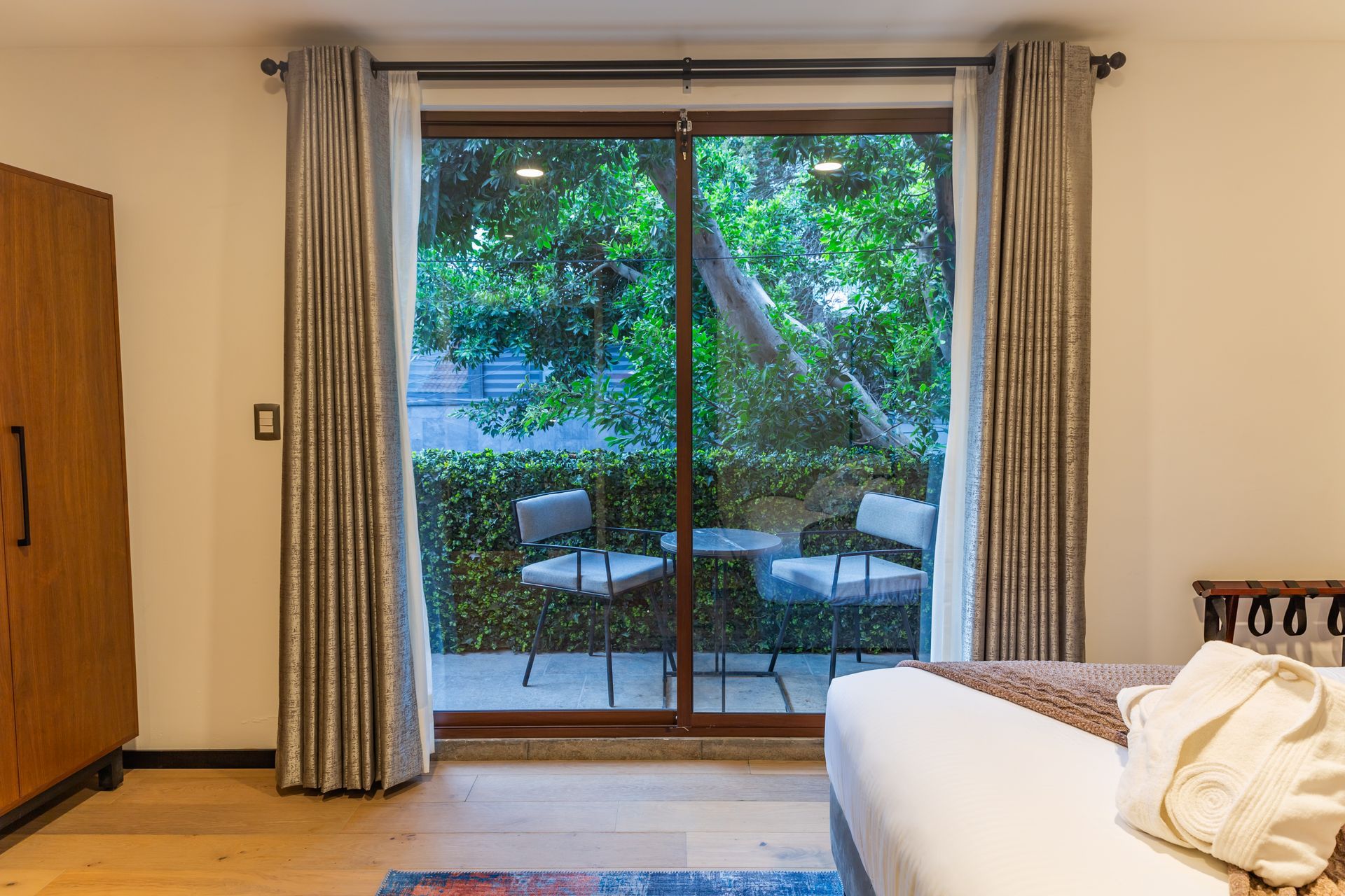 Un dormitorio con una cama y una puerta corrediza de vidrio que conduce a un balcón.