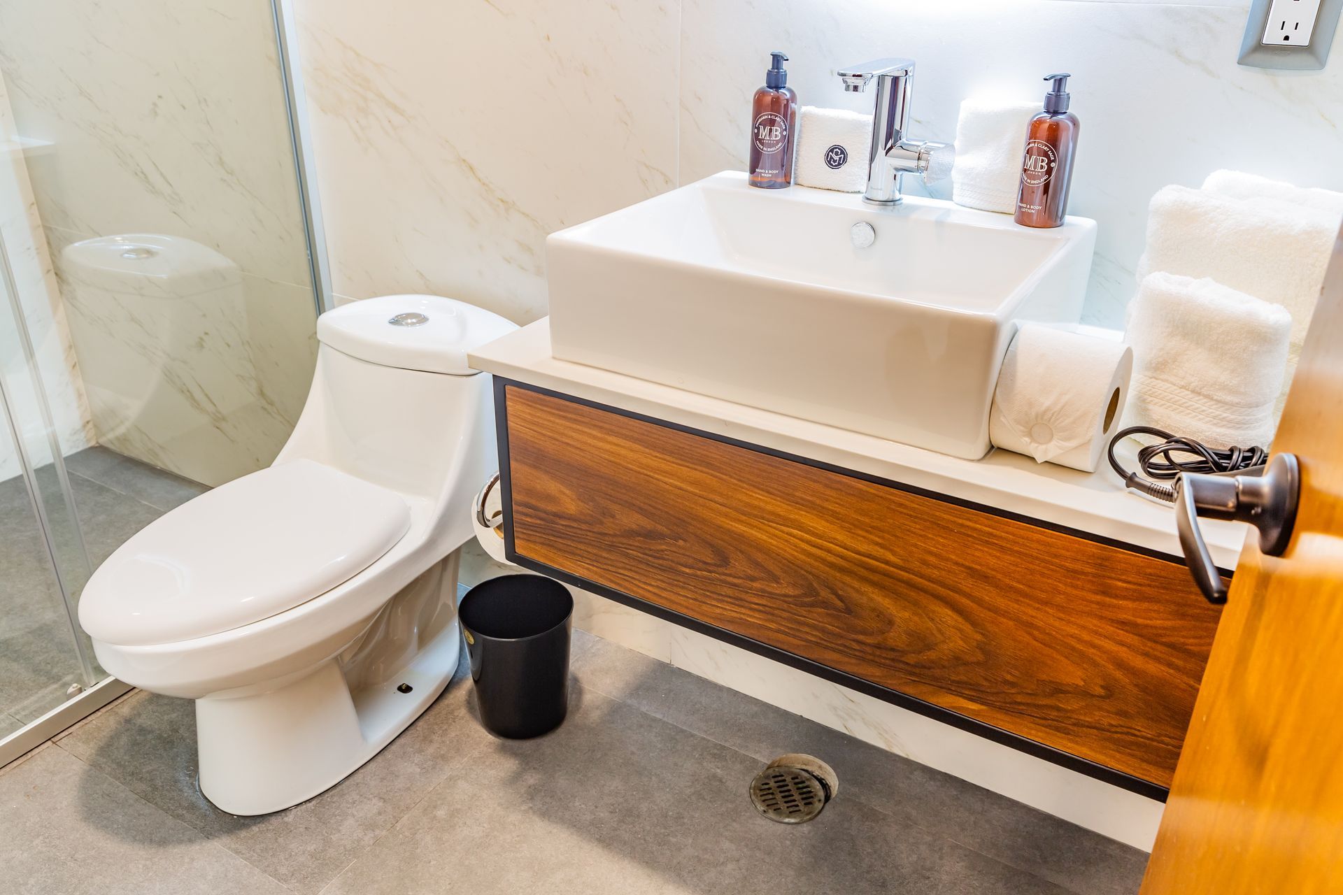 Un baño con inodoro, lavabo y ducha.