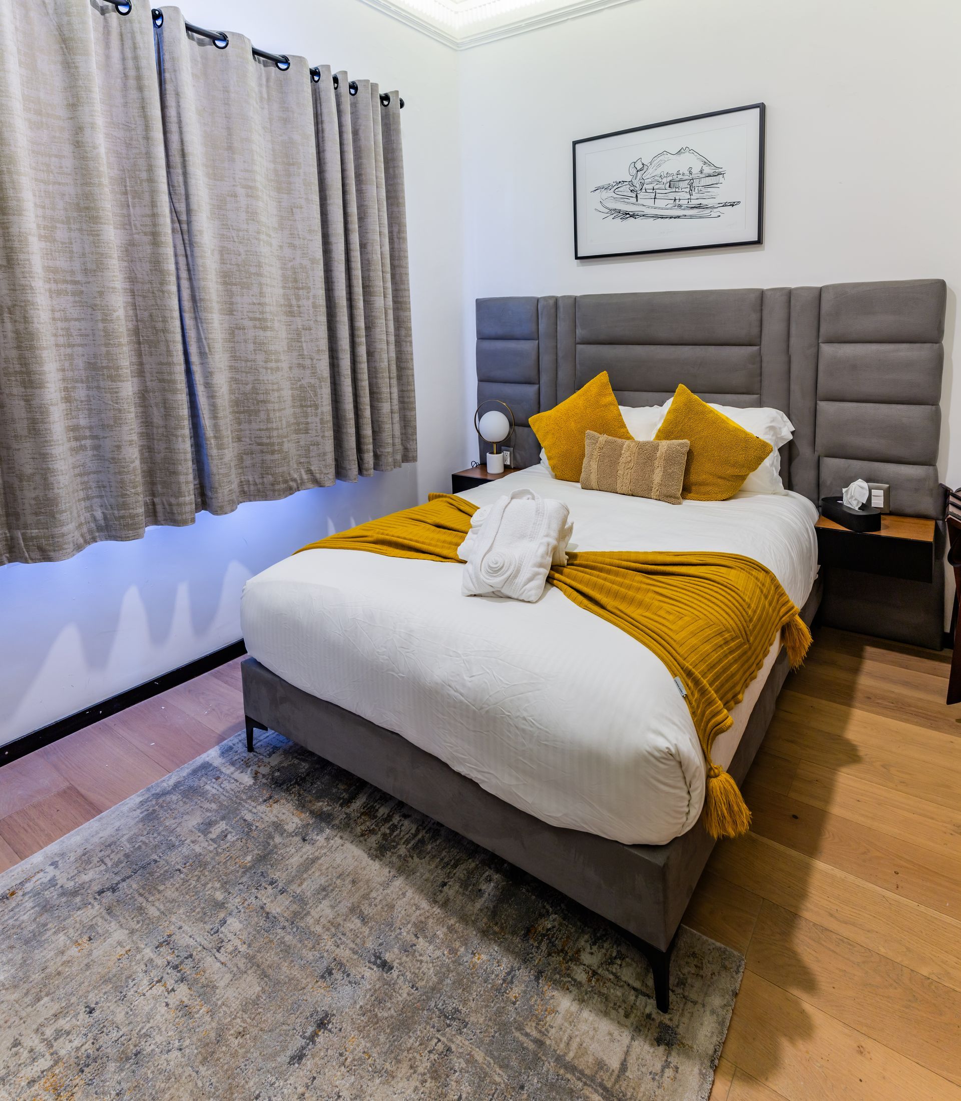 A bedroom with a king size bed , two nightstands , and a rug.