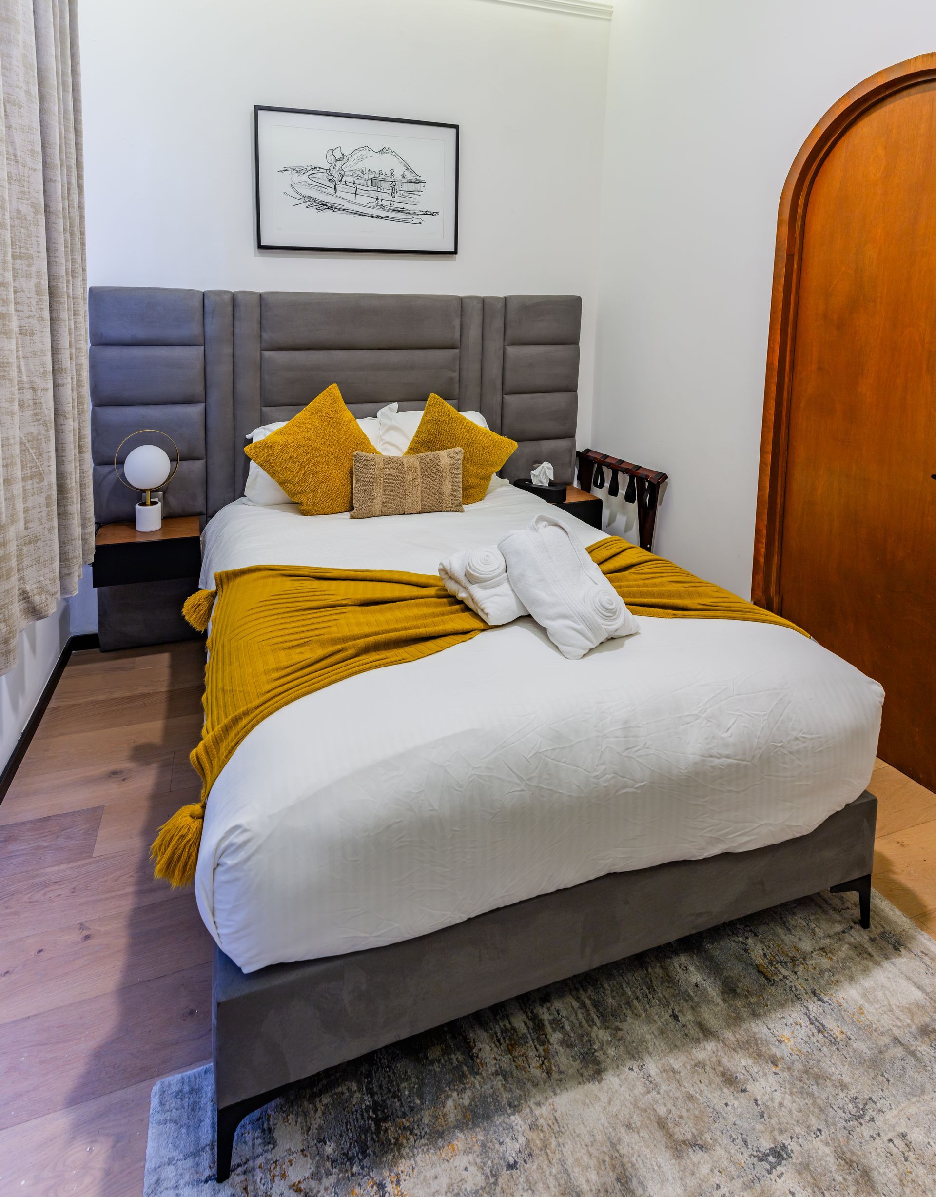 A bed with a yellow blanket and pillows in a bedroom