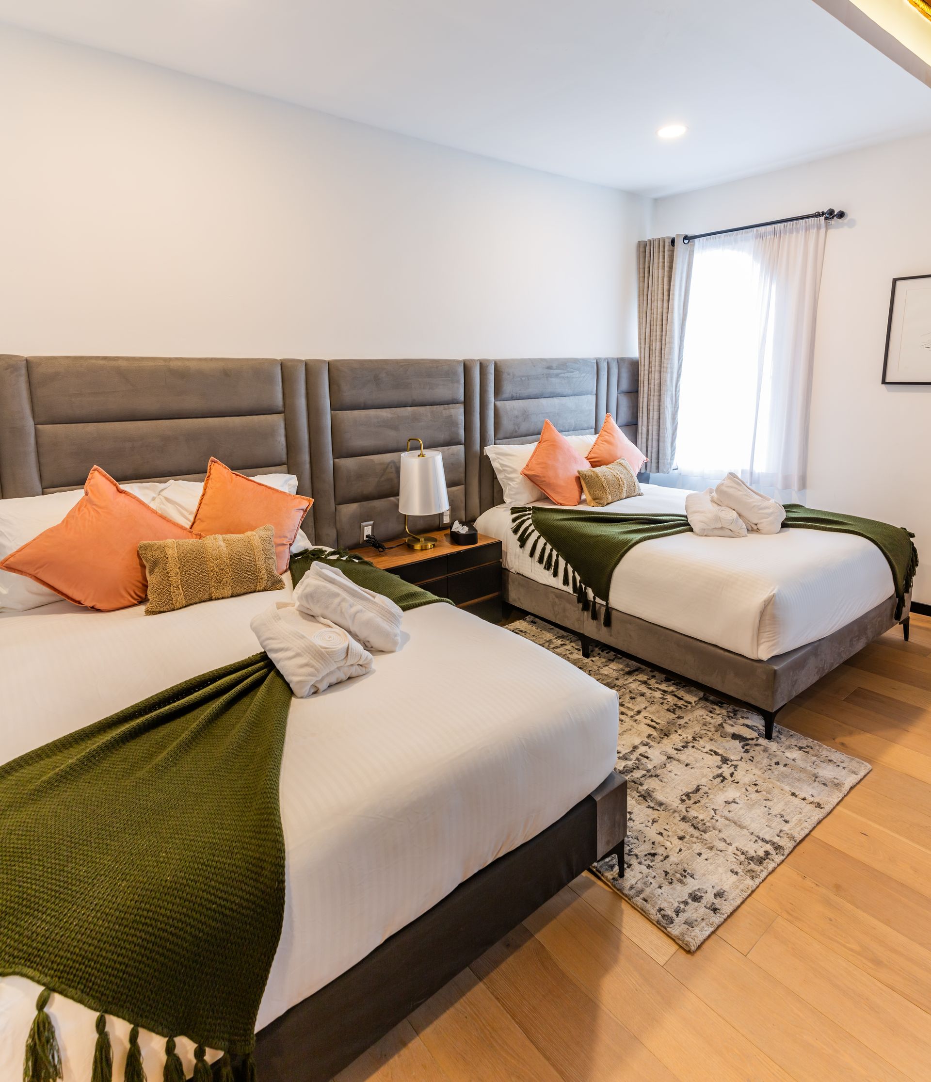 Una habitación de hotel con dos camas y una alfombra.