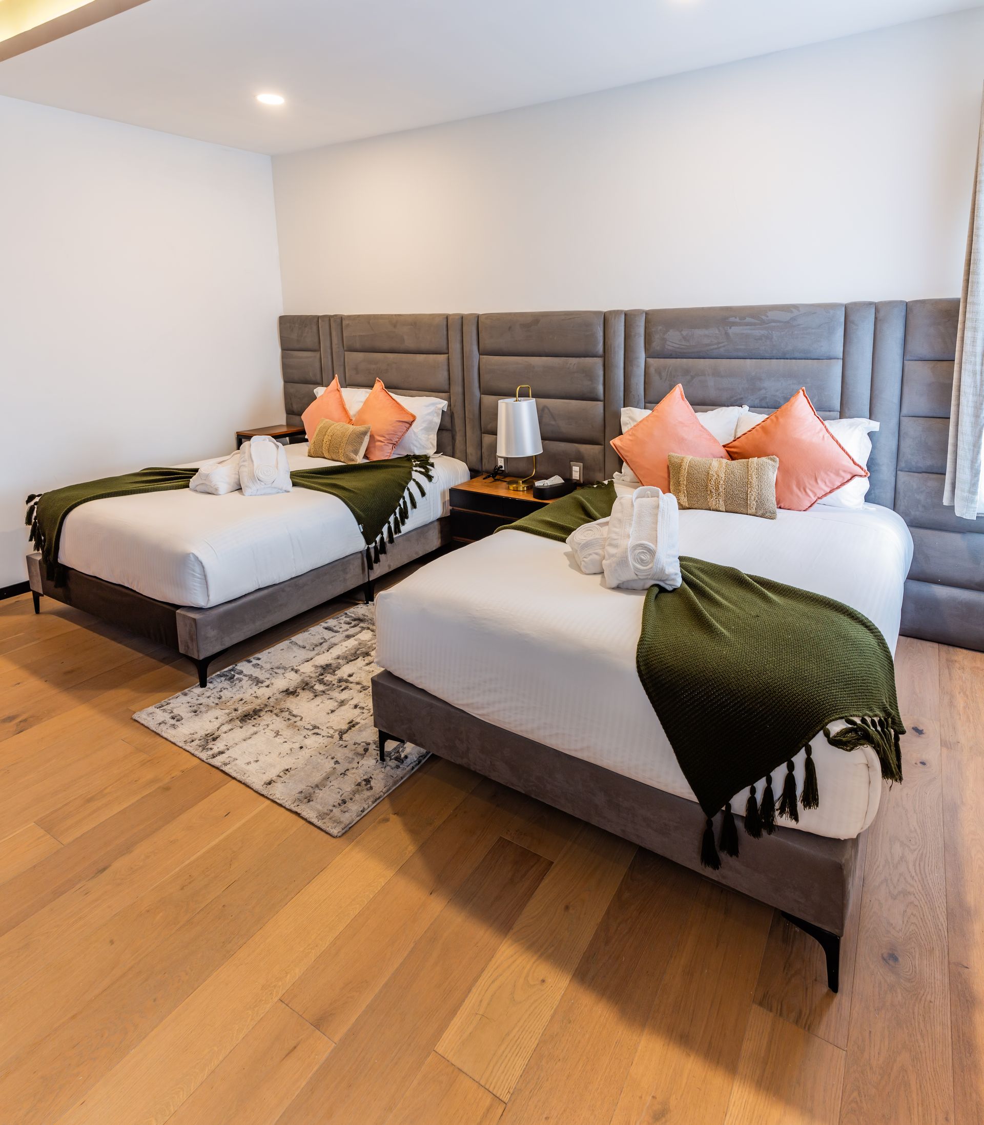 Una habitación de hotel con dos camas y una alfombra en el suelo.