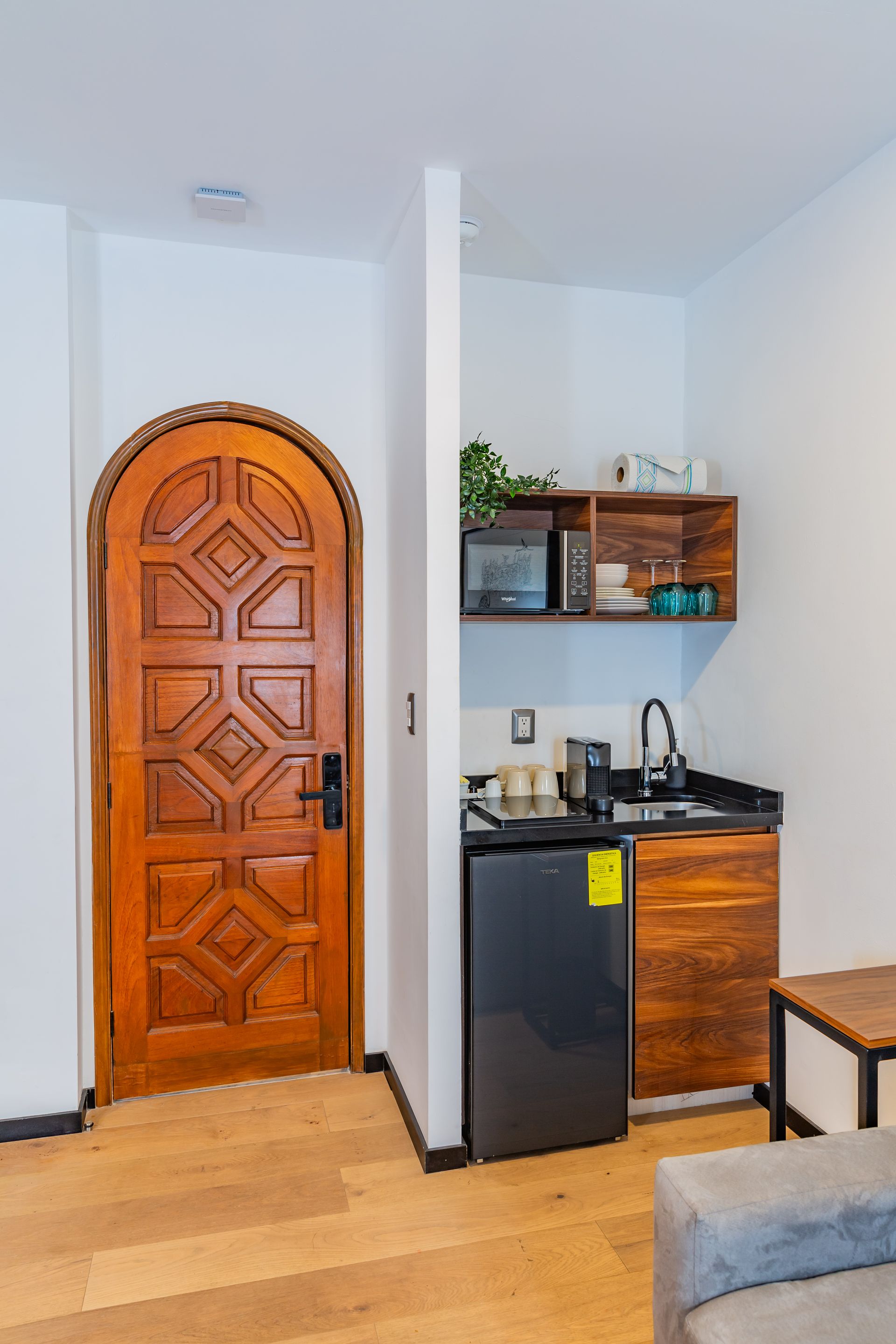 Una pequeña cocina con refrigerador, fregadero y microondas.