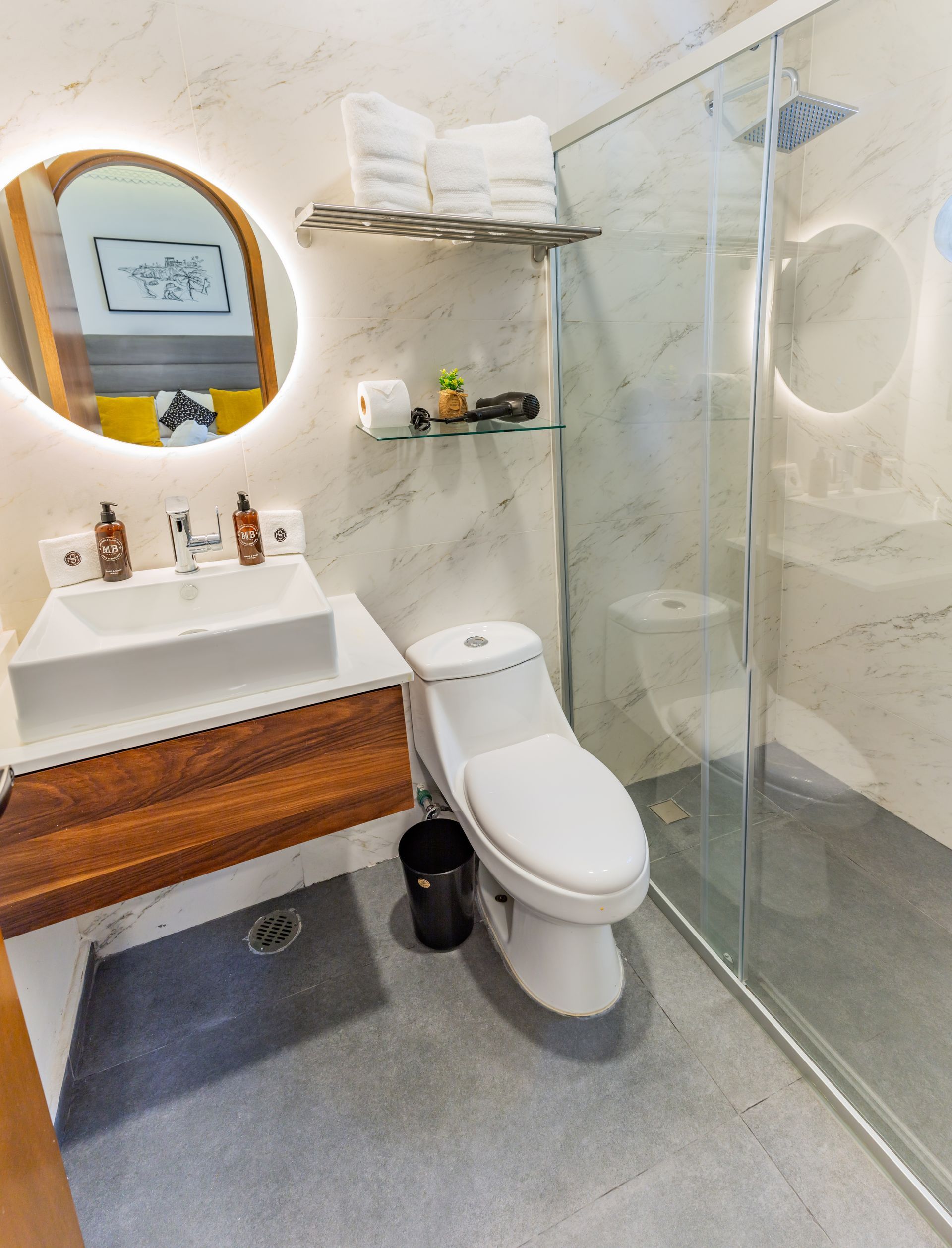 Un baño con inodoro, lavabo, espejo y ducha.
