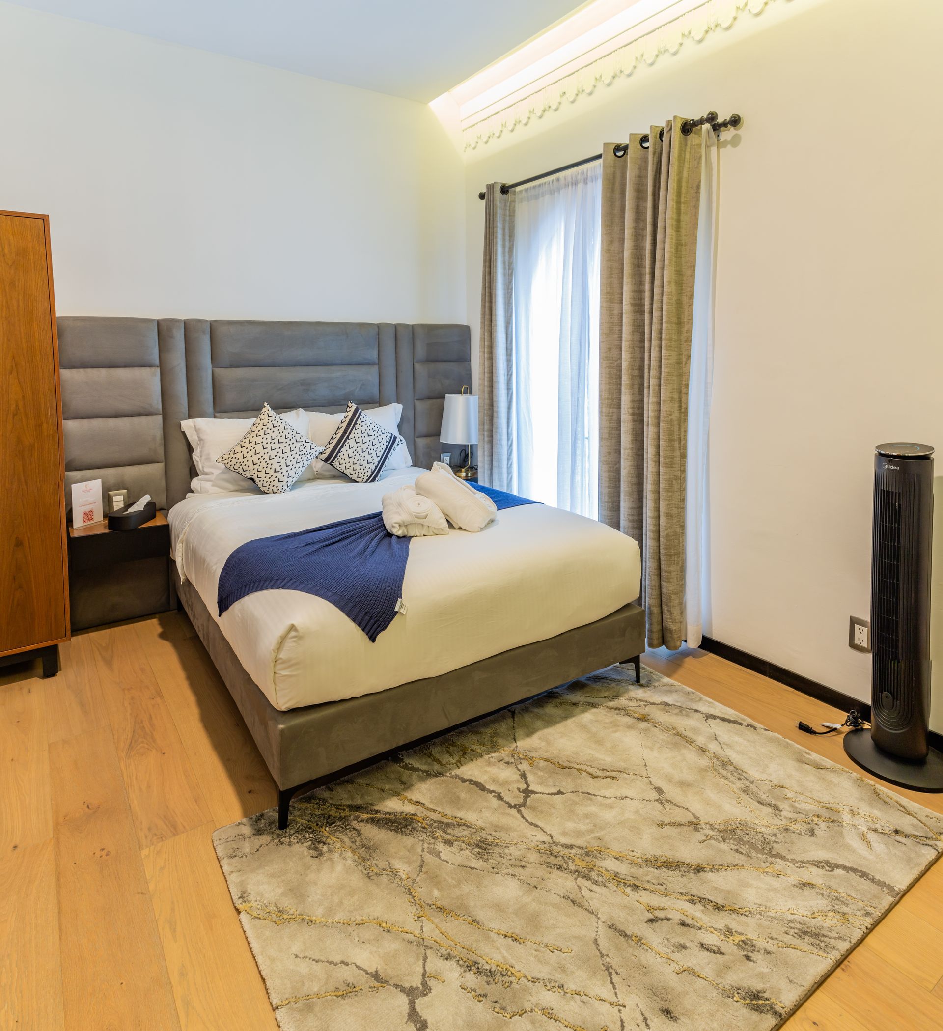 Un dormitorio con una cama king size y una alfombra.