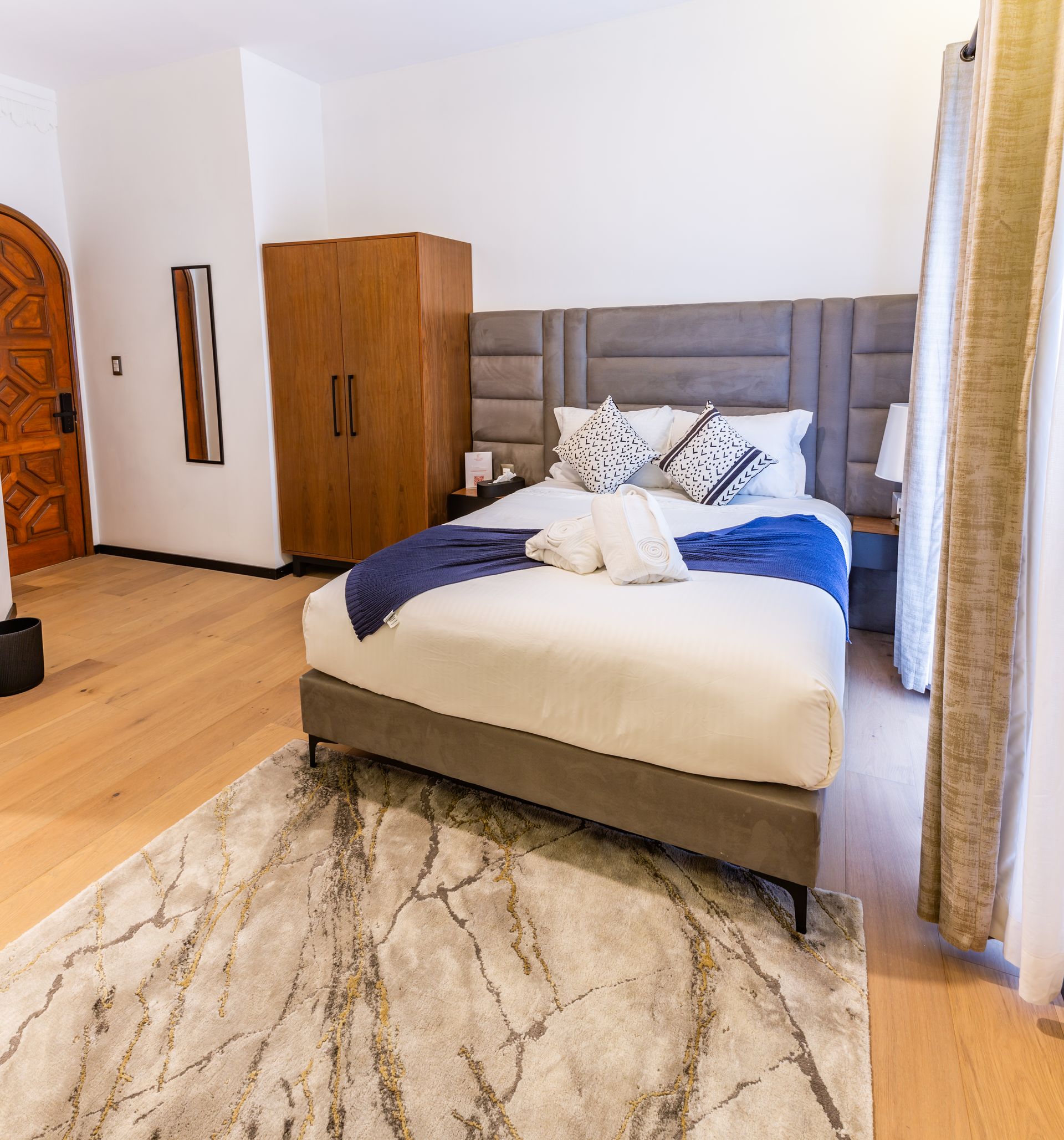 Una habitación de hotel con una cama grande y una alfombra.