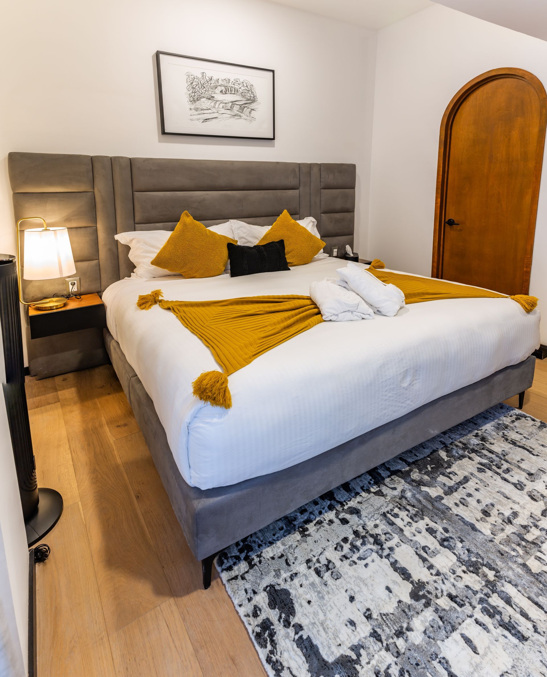 Un dormitorio con una cama grande y una alfombra en el suelo.