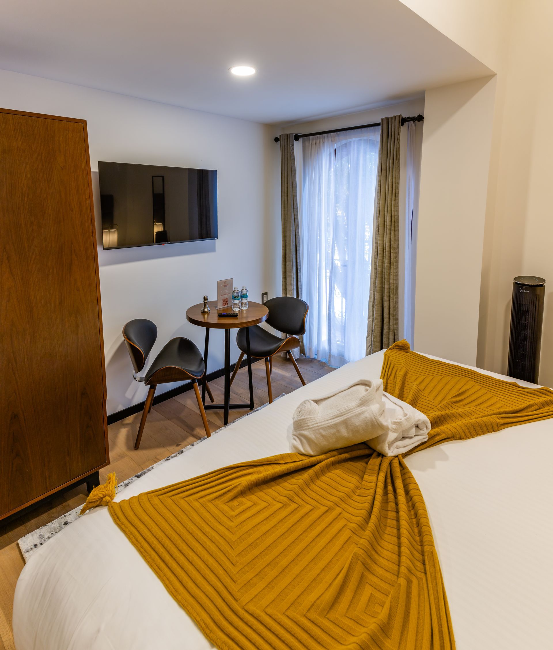 Una habitación de hotel con cama, mesa y sillas.