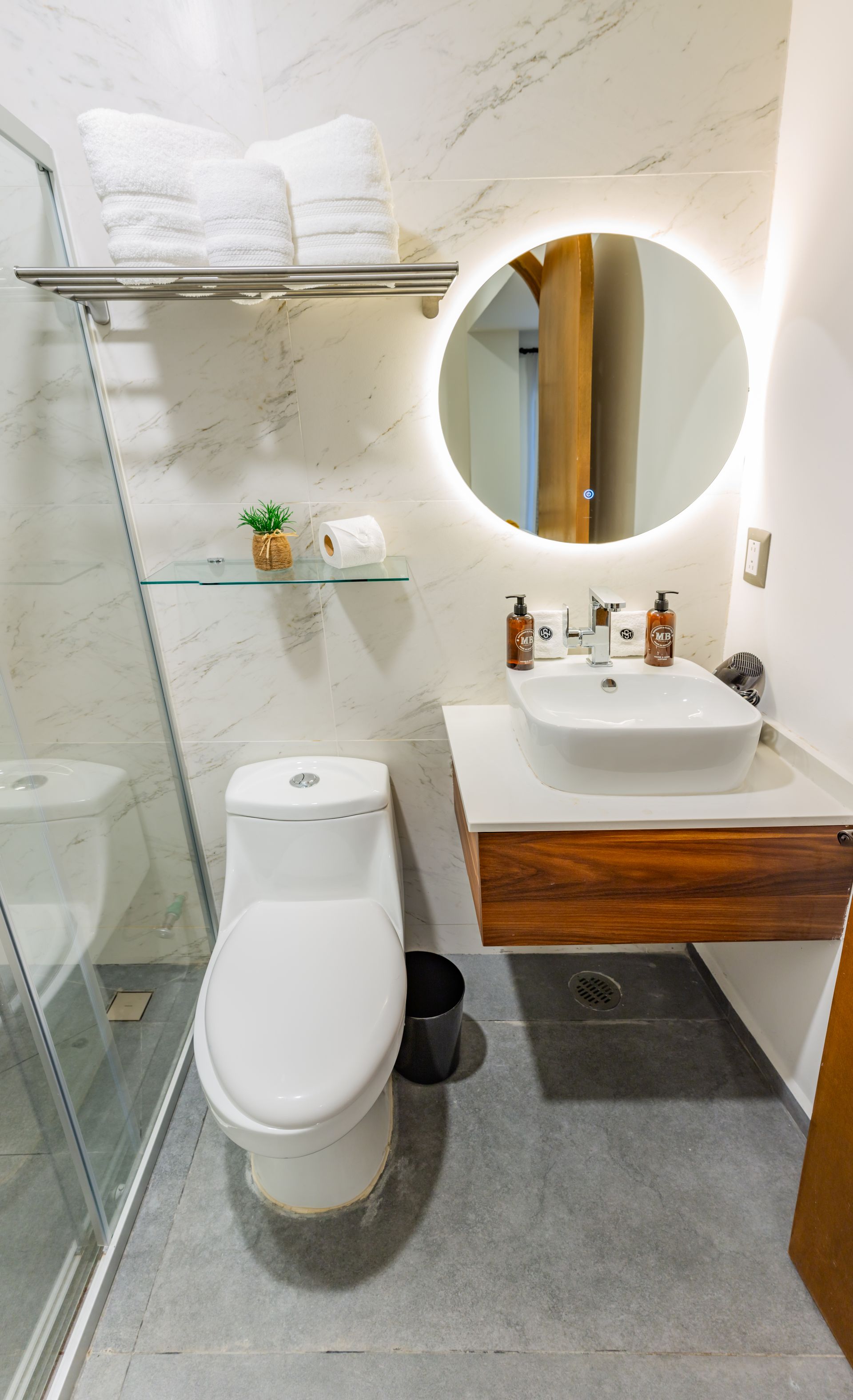 Un baño con inodoro, lavabo y espejo.