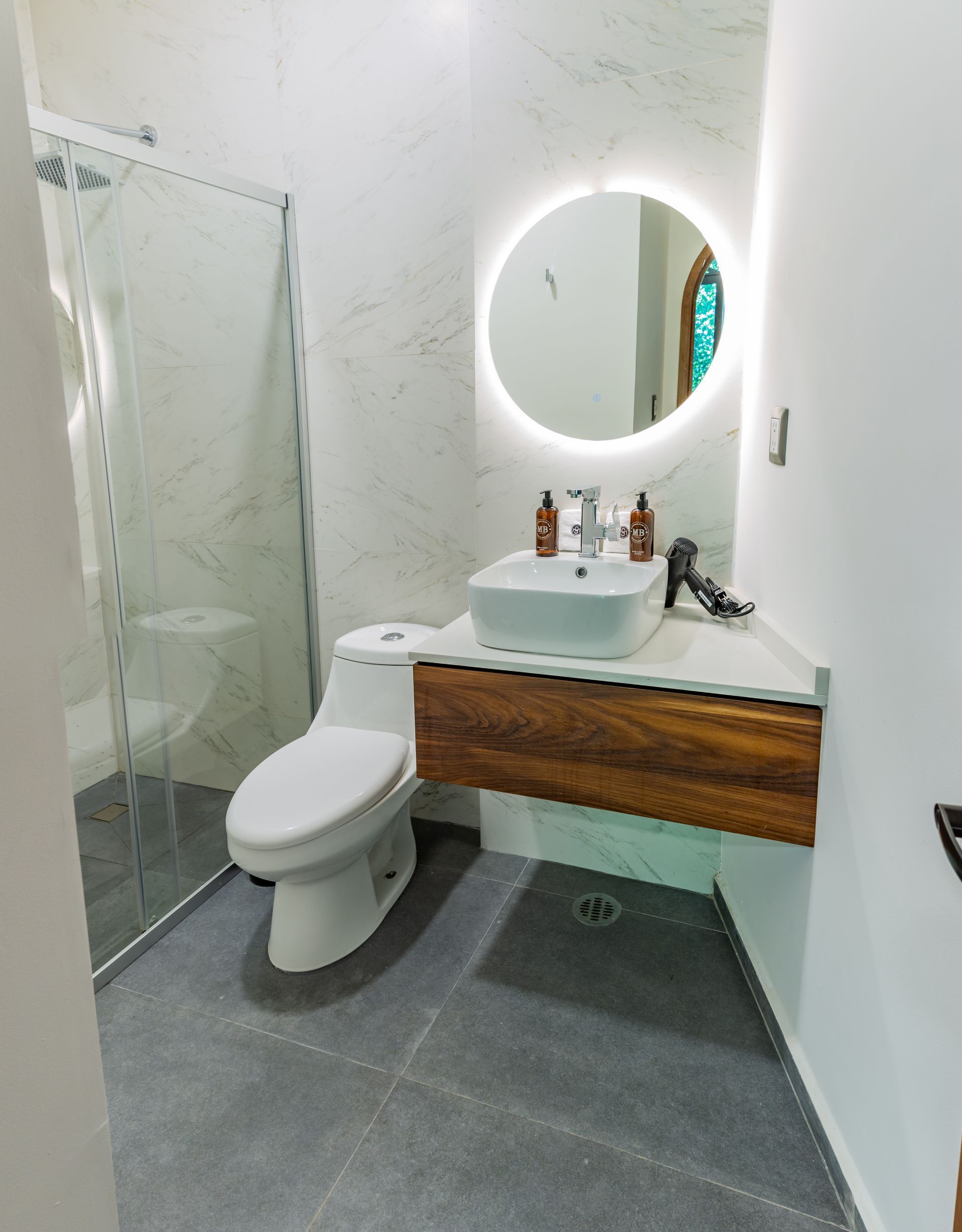 Un baño con inodoro, lavabo y espejo.