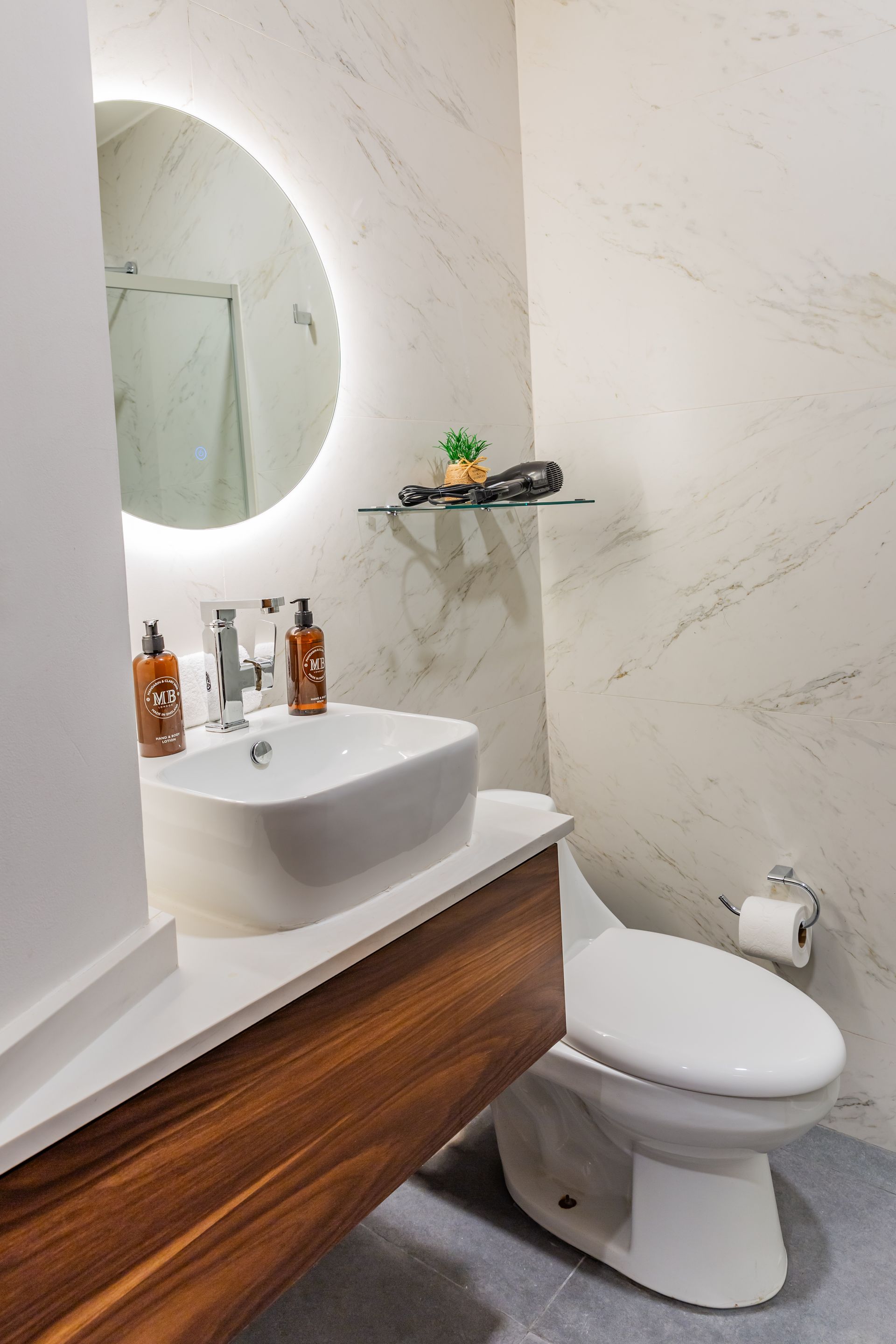 Un baño con inodoro, lavabo y espejo.