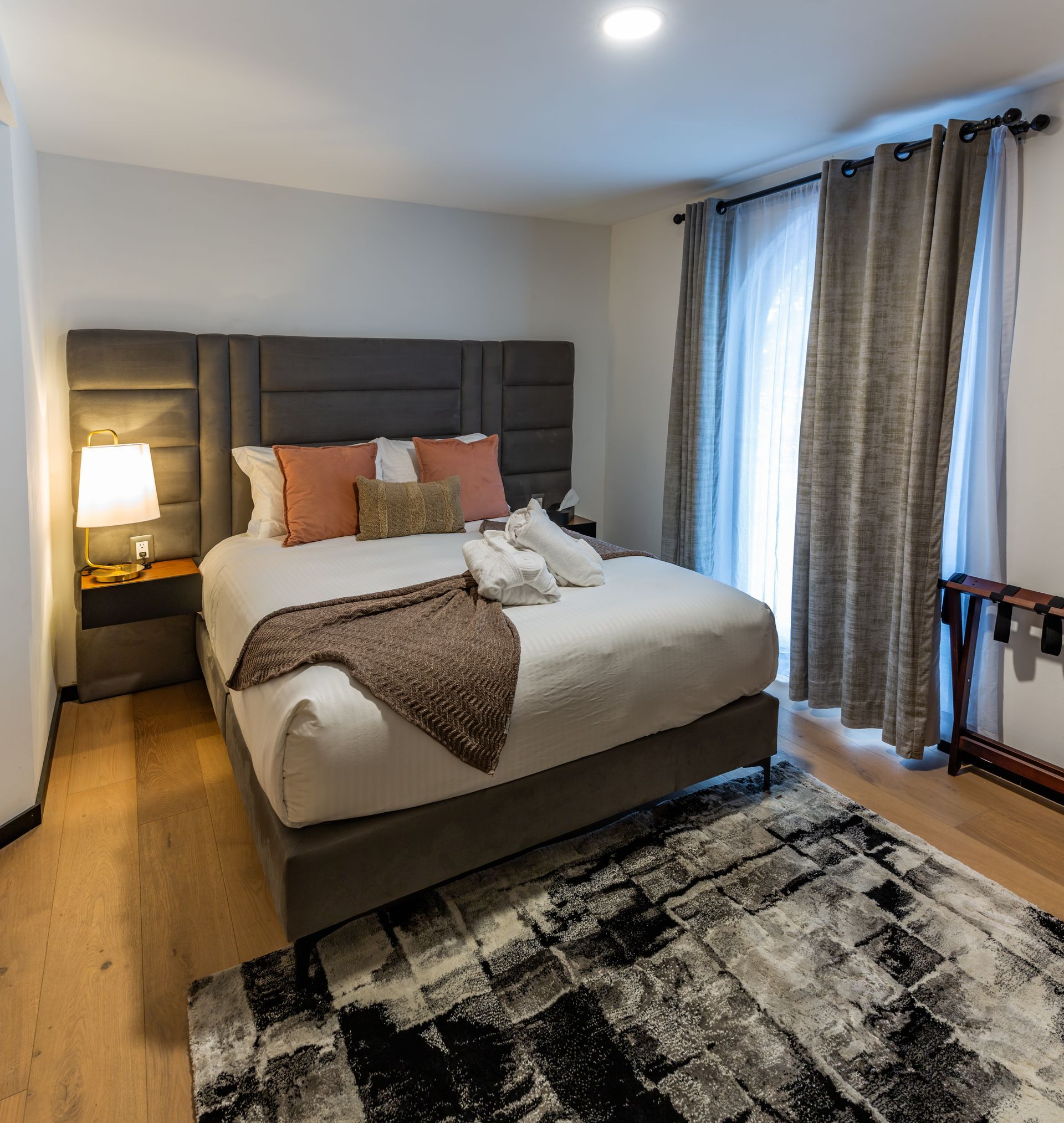 Una habitación de hotel con una cama grande y una alfombra.