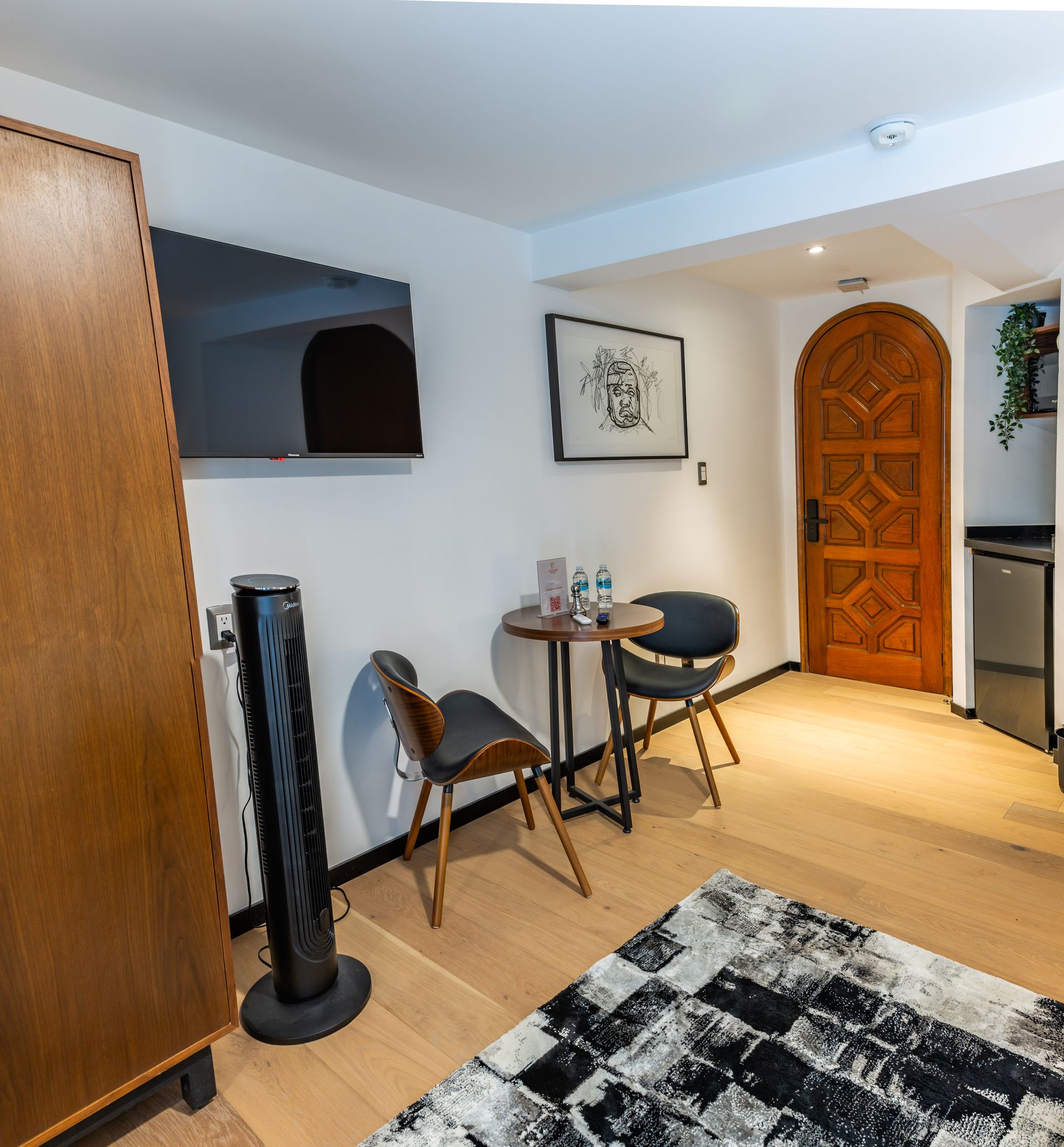 Una sala de estar con una mesa y sillas y una alfombra.