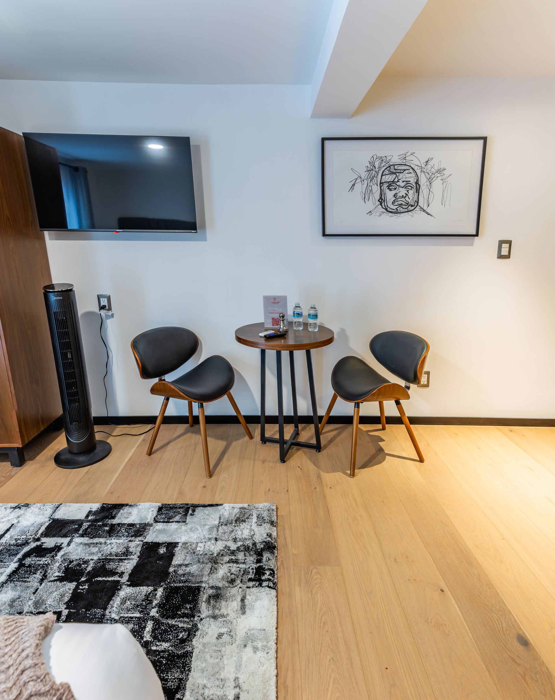 Una sala de estar con dos sillas y una mesa pequeña.