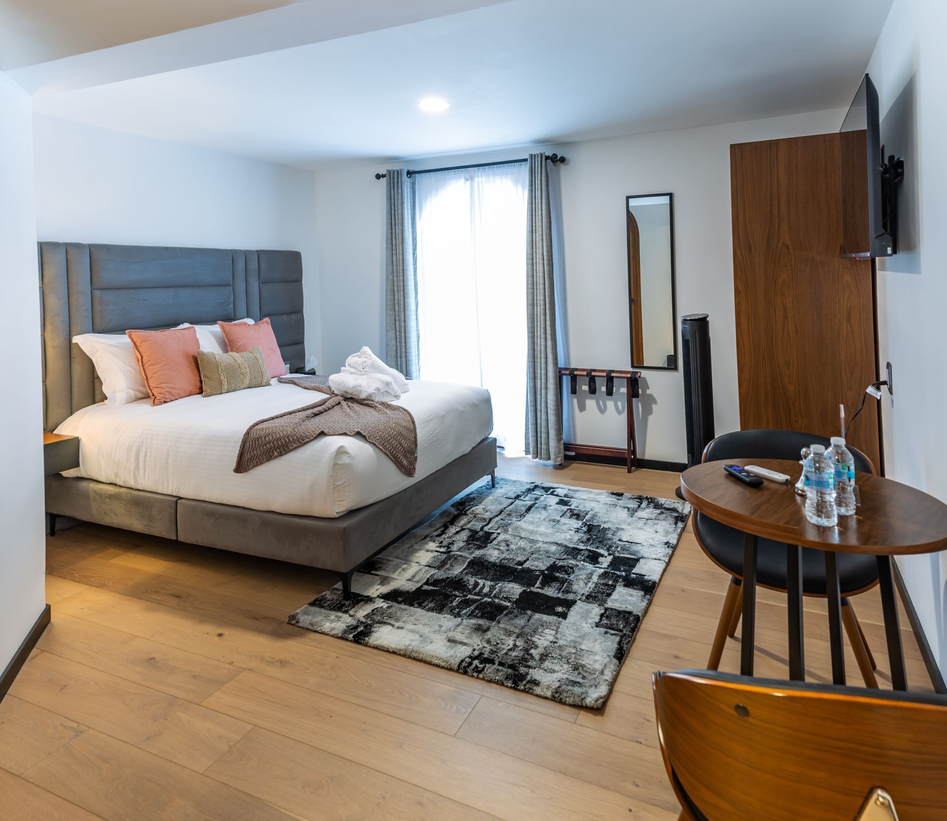 Una habitación de hotel con una cama grande y una mesa.
