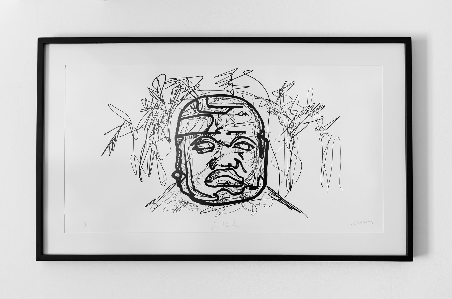 Un dibujo en blanco y negro del rostro de un hombre en un marco en una pared.