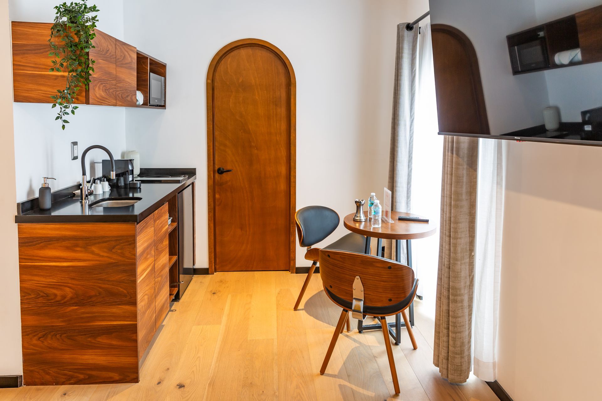 Una cocina con muebles de madera, un fregadero, una mesa y sillas.