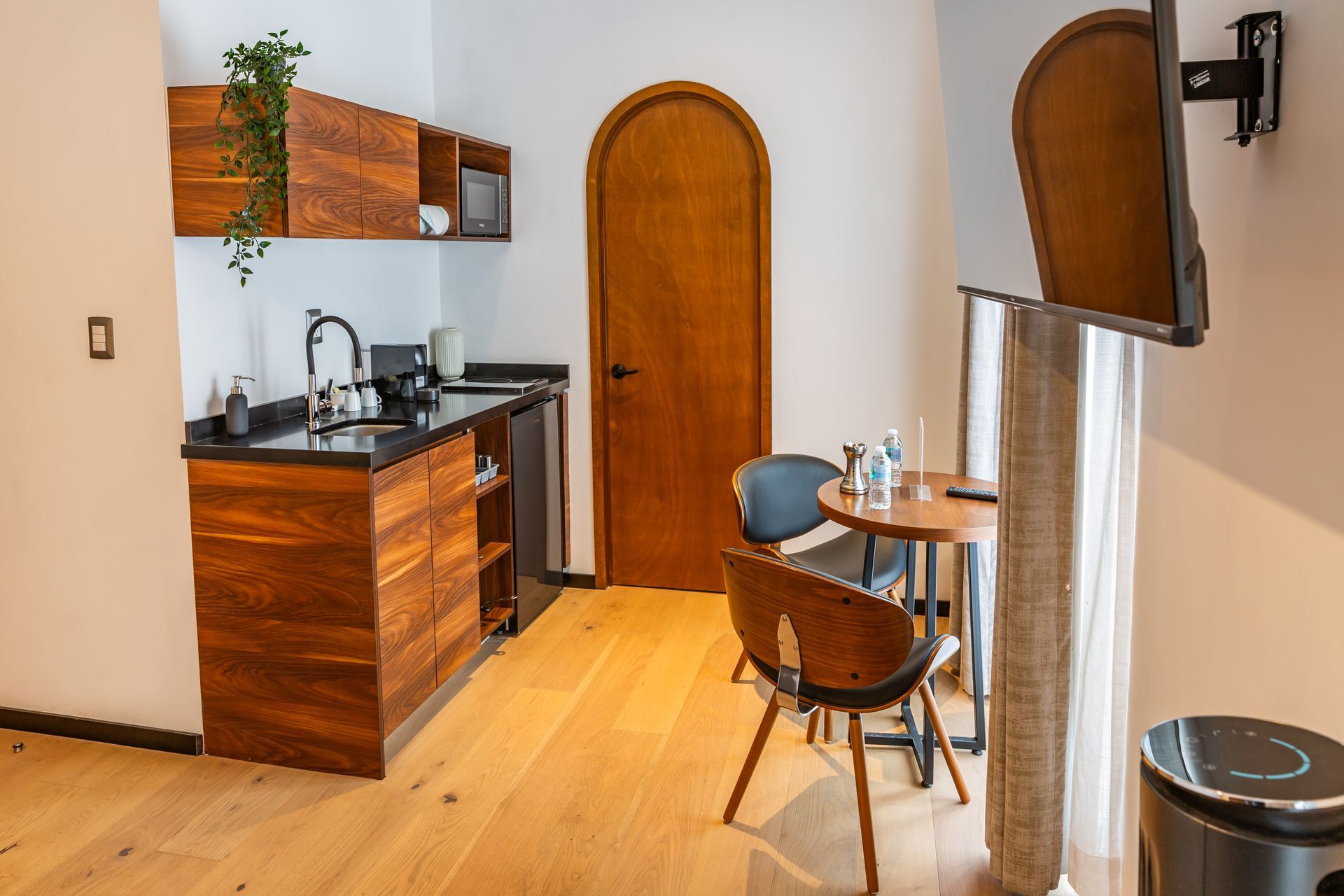 Una cocina con muebles de madera, un fregadero, una mesa y sillas.