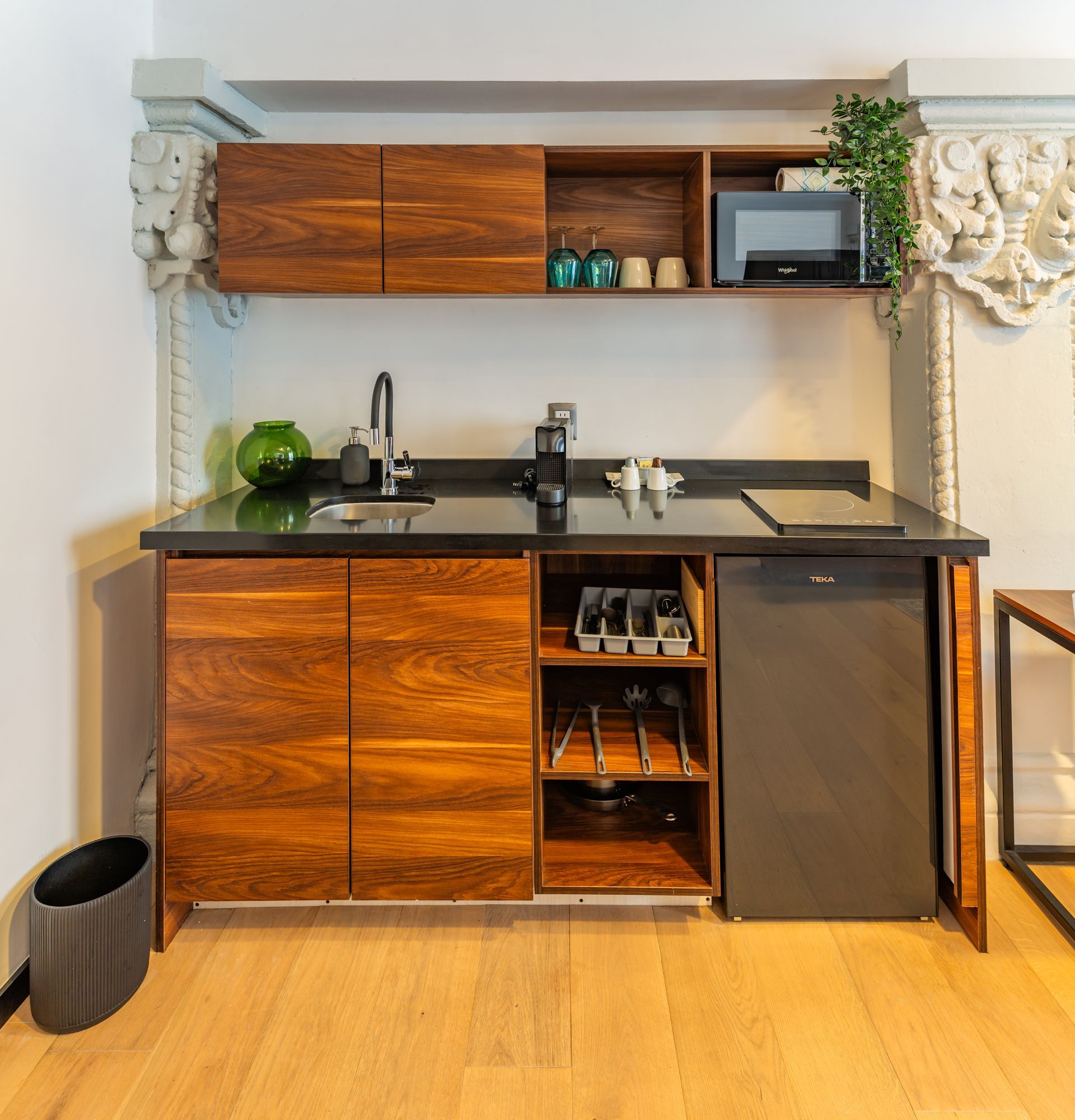 Una cocina con gabinetes de madera y lavavajillas negro.