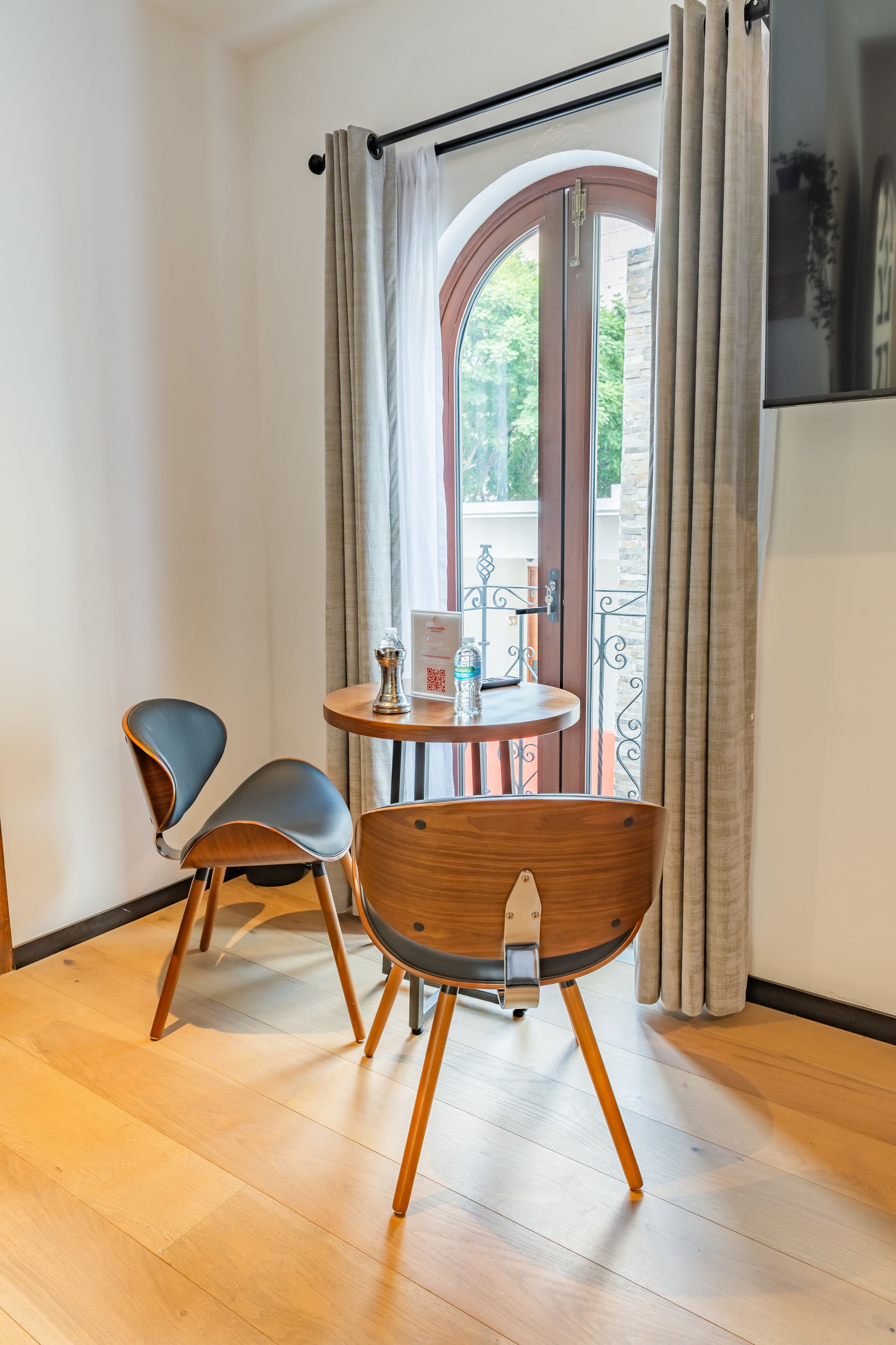 Una habitación con una mesa y sillas frente a una ventana.