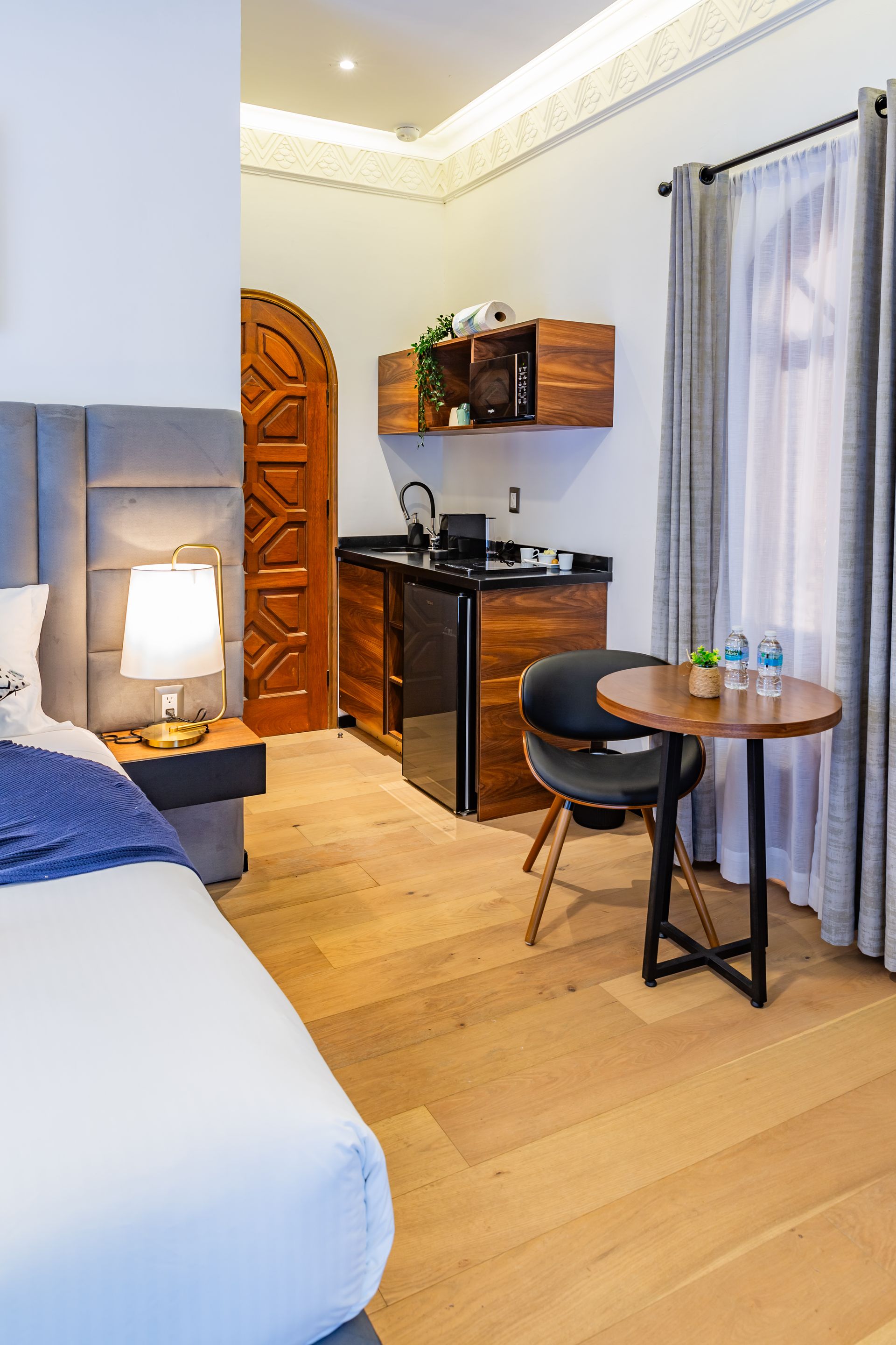 Una habitación de hotel con una cama, mesa y sillas.