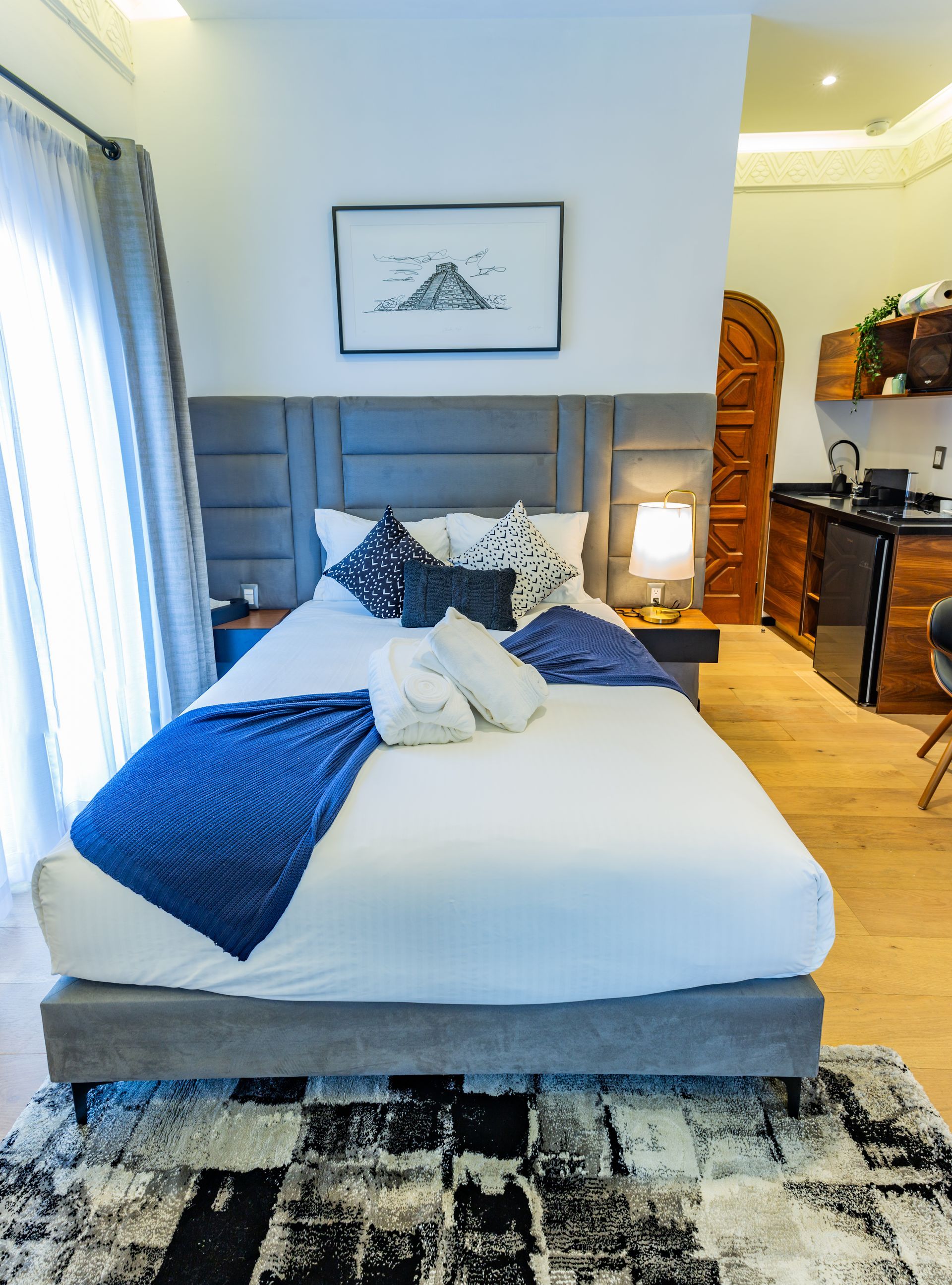 Un dormitorio con una cama grande y una alfombra en el suelo.