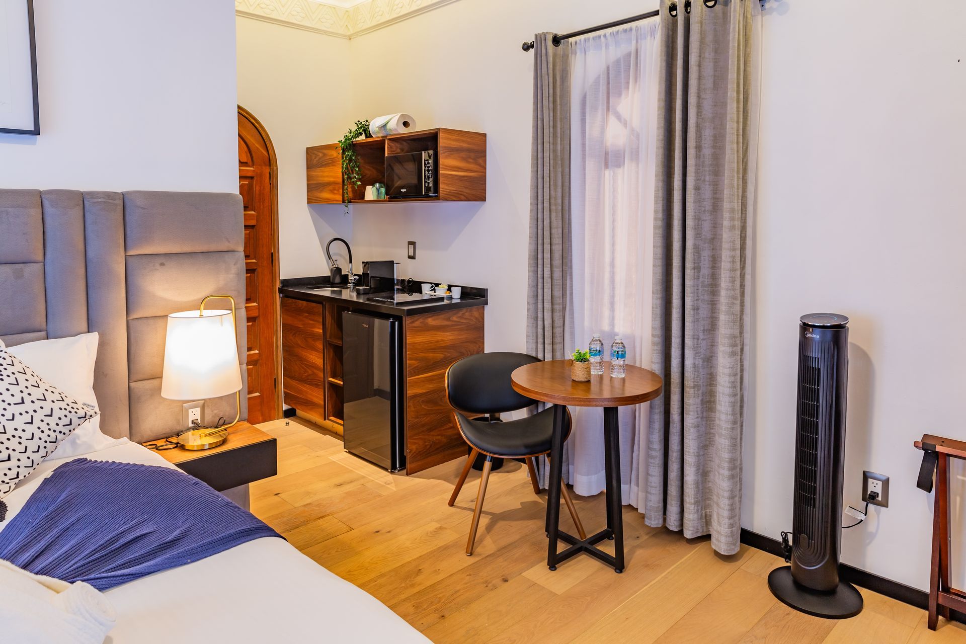 Una habitación de hotel con una cama, mesa y sillas.