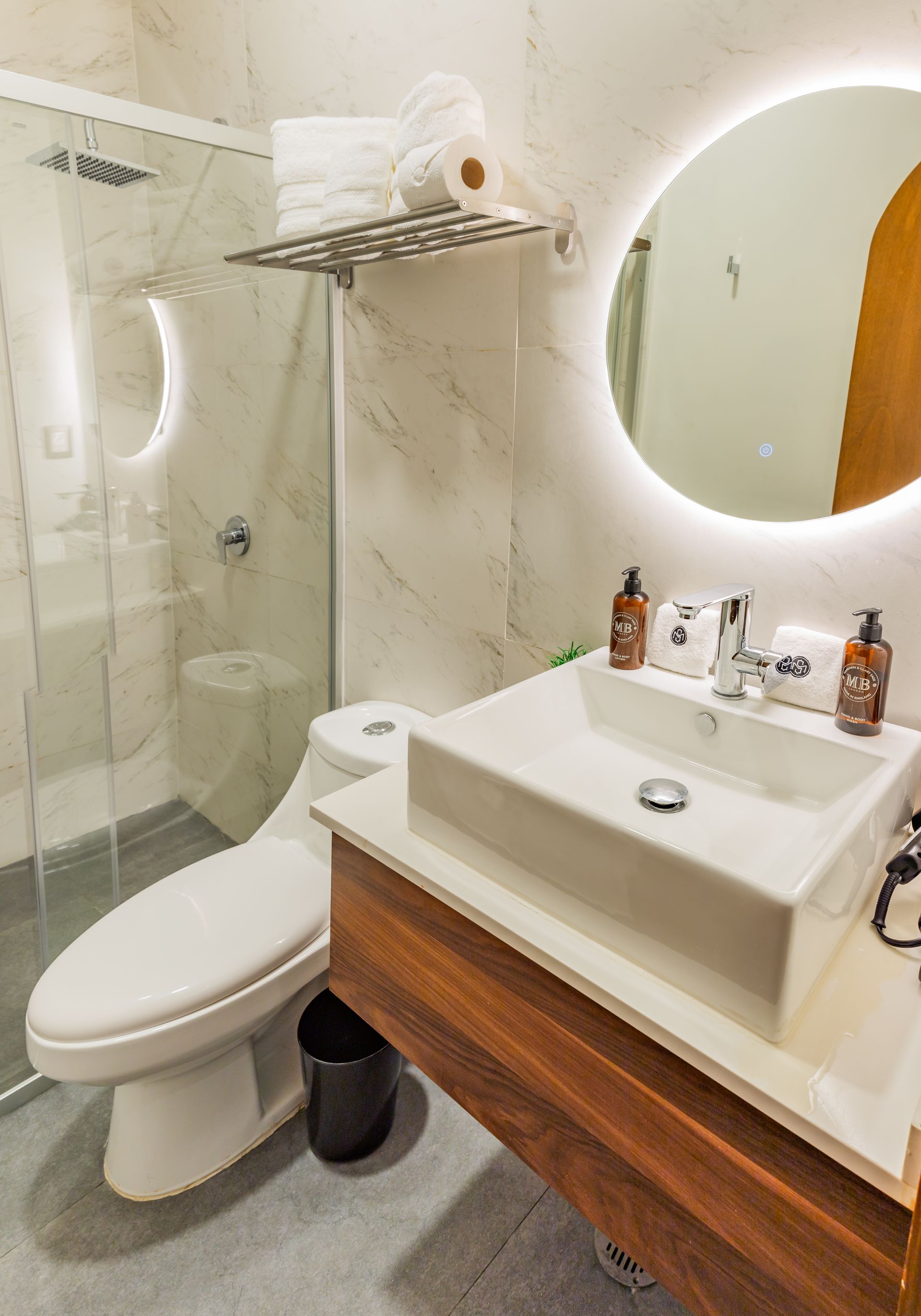 Un baño con inodoro, lavabo, espejo y ducha.