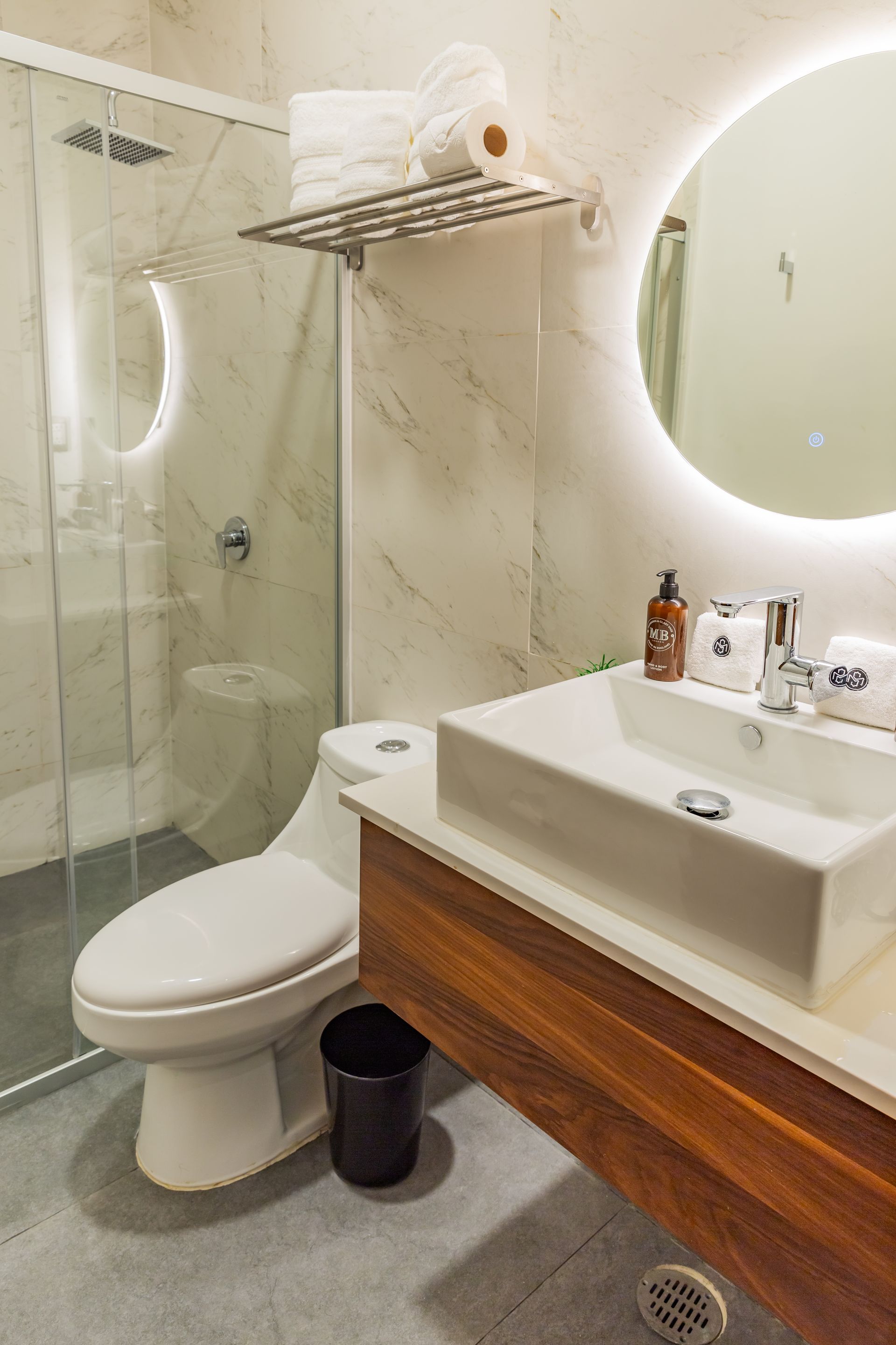 Un baño con inodoro, lavabo, espejo y ducha.