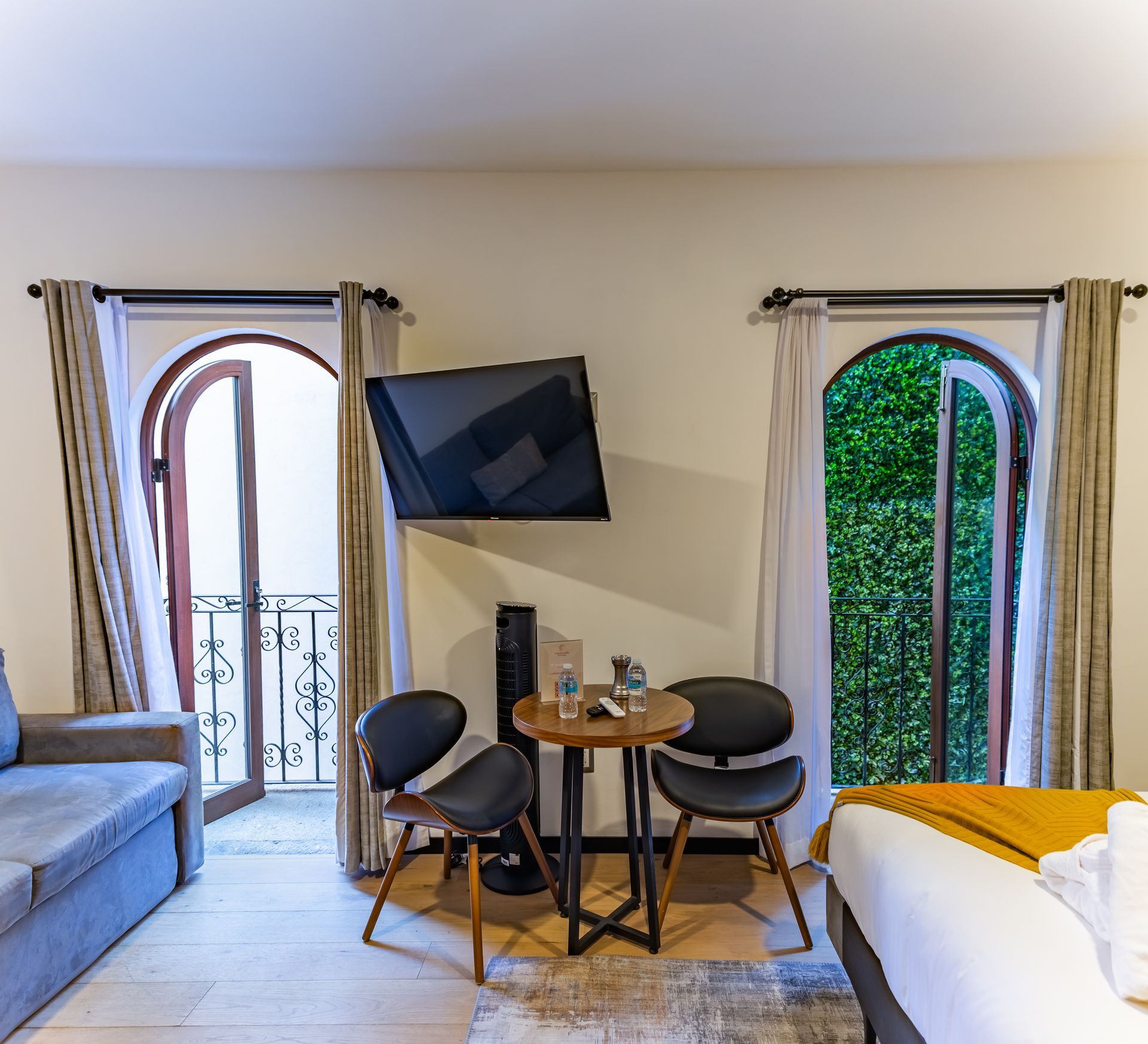 Una habitación de hotel con una mesa, sillas y un televisor de pantalla plana.