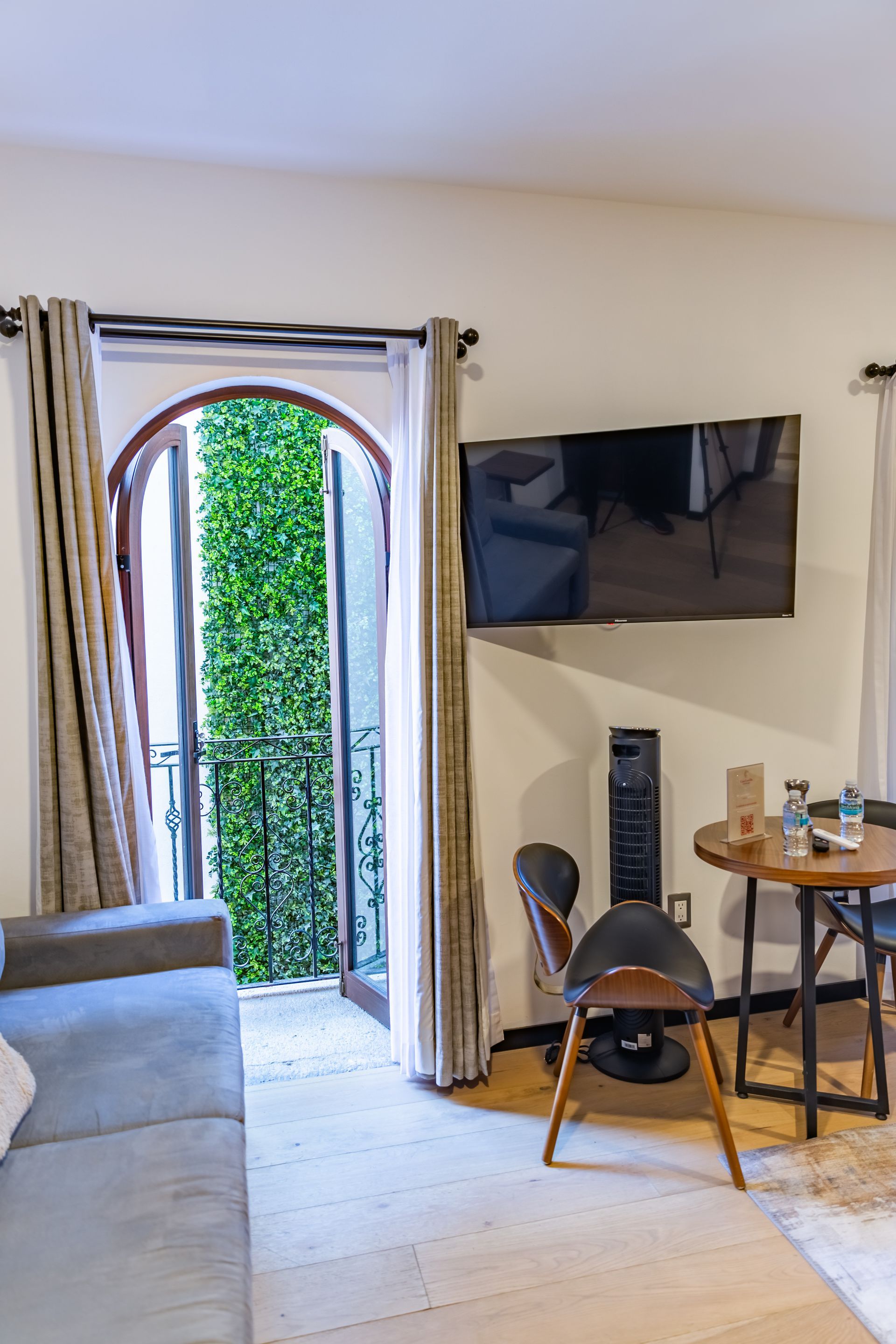 Una sala de estar con sofá, silla, mesa y televisión.
