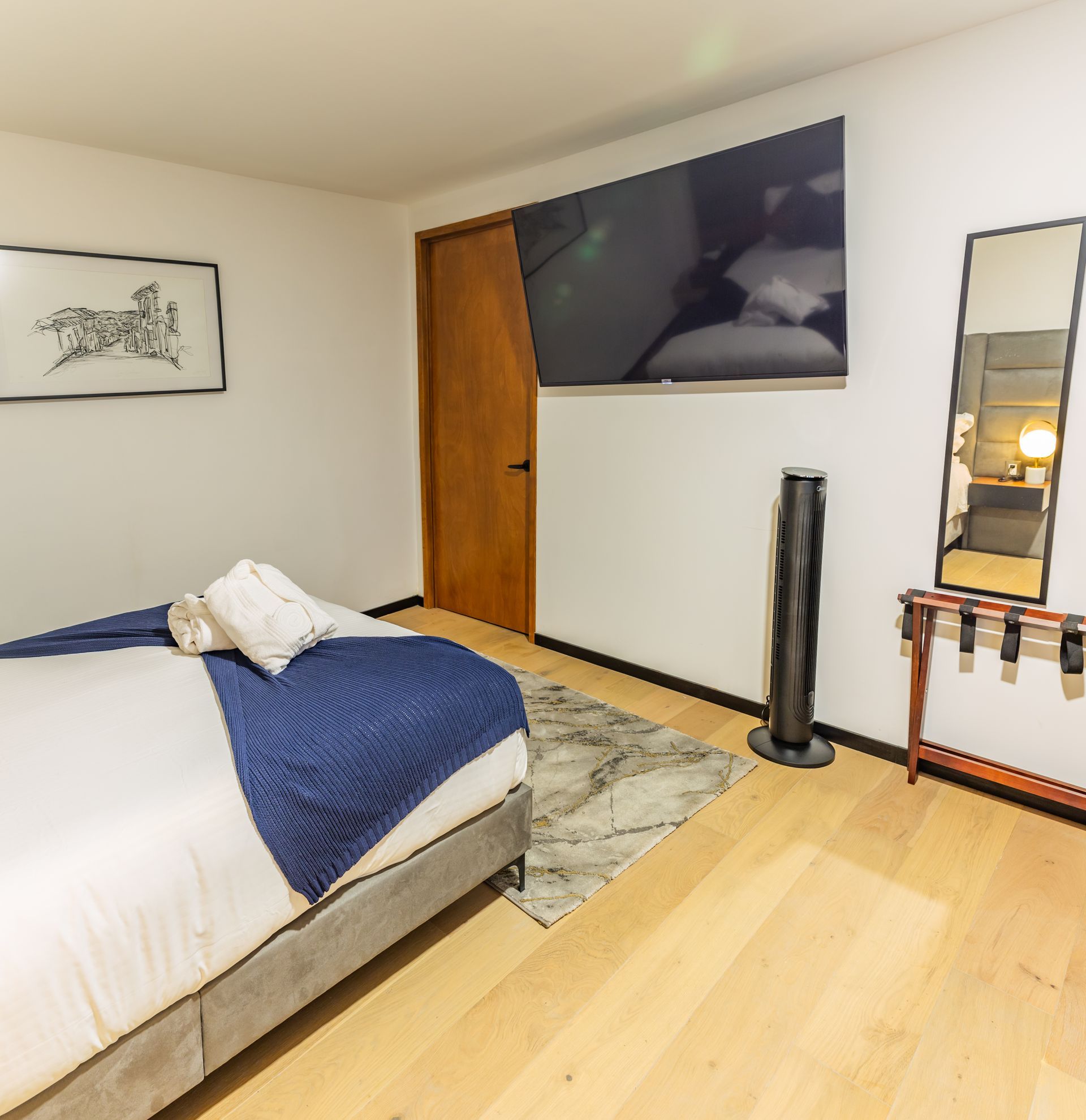 Un dormitorio con una cama grande y un espejo.