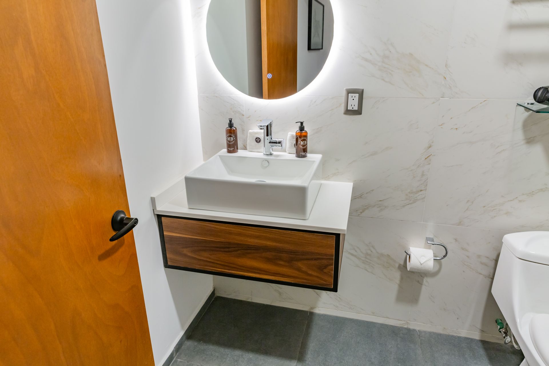 Un baño con lavabo, inodoro y espejo.