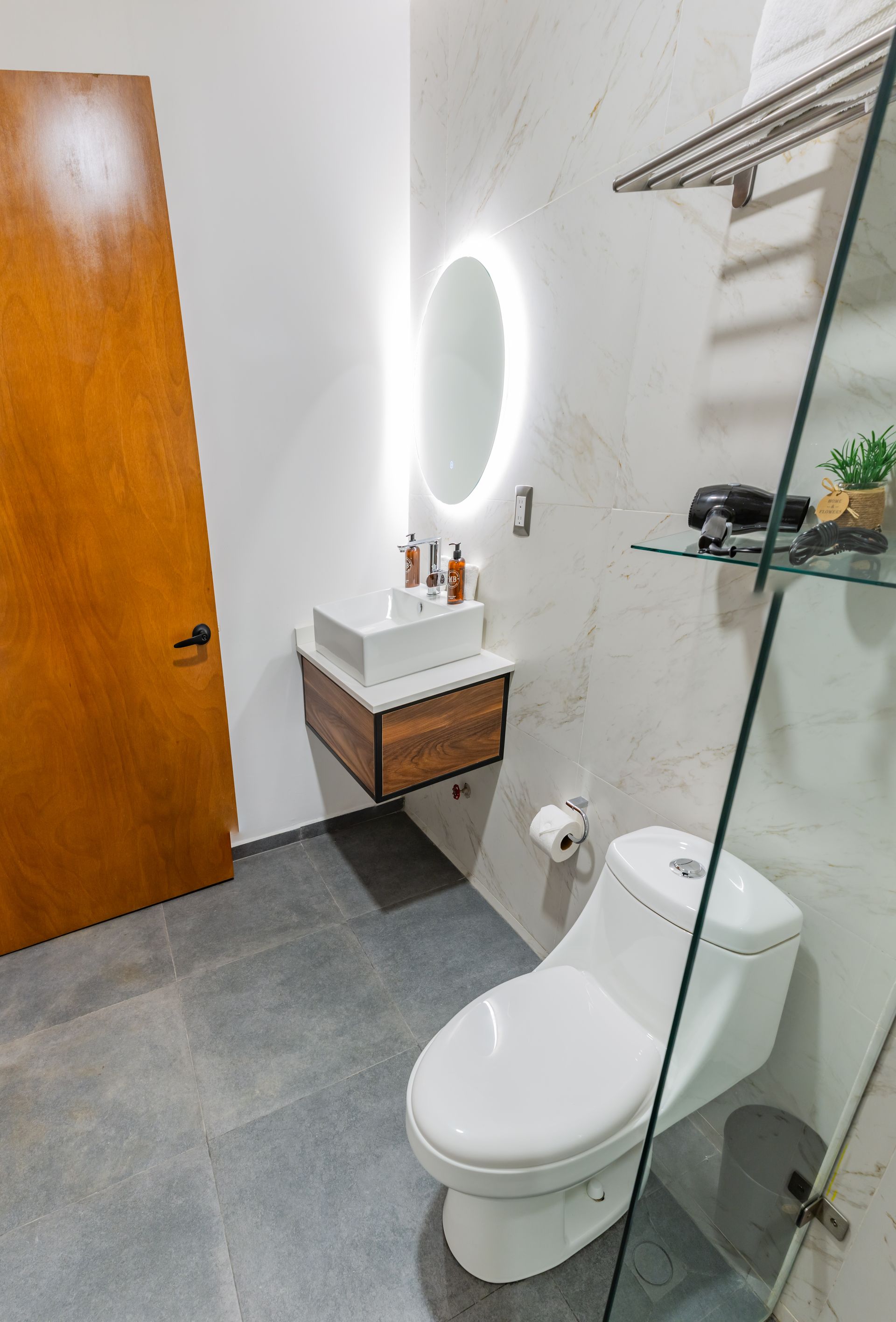 Un baño con inodoro, lavabo y espejo.