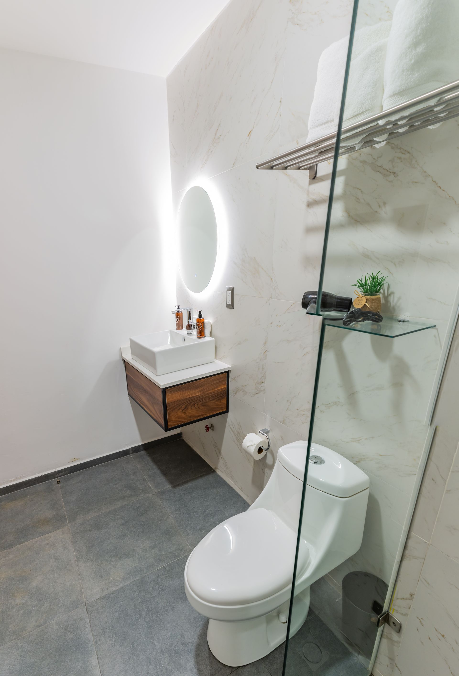 Un baño con inodoro, lavabo y espejo.