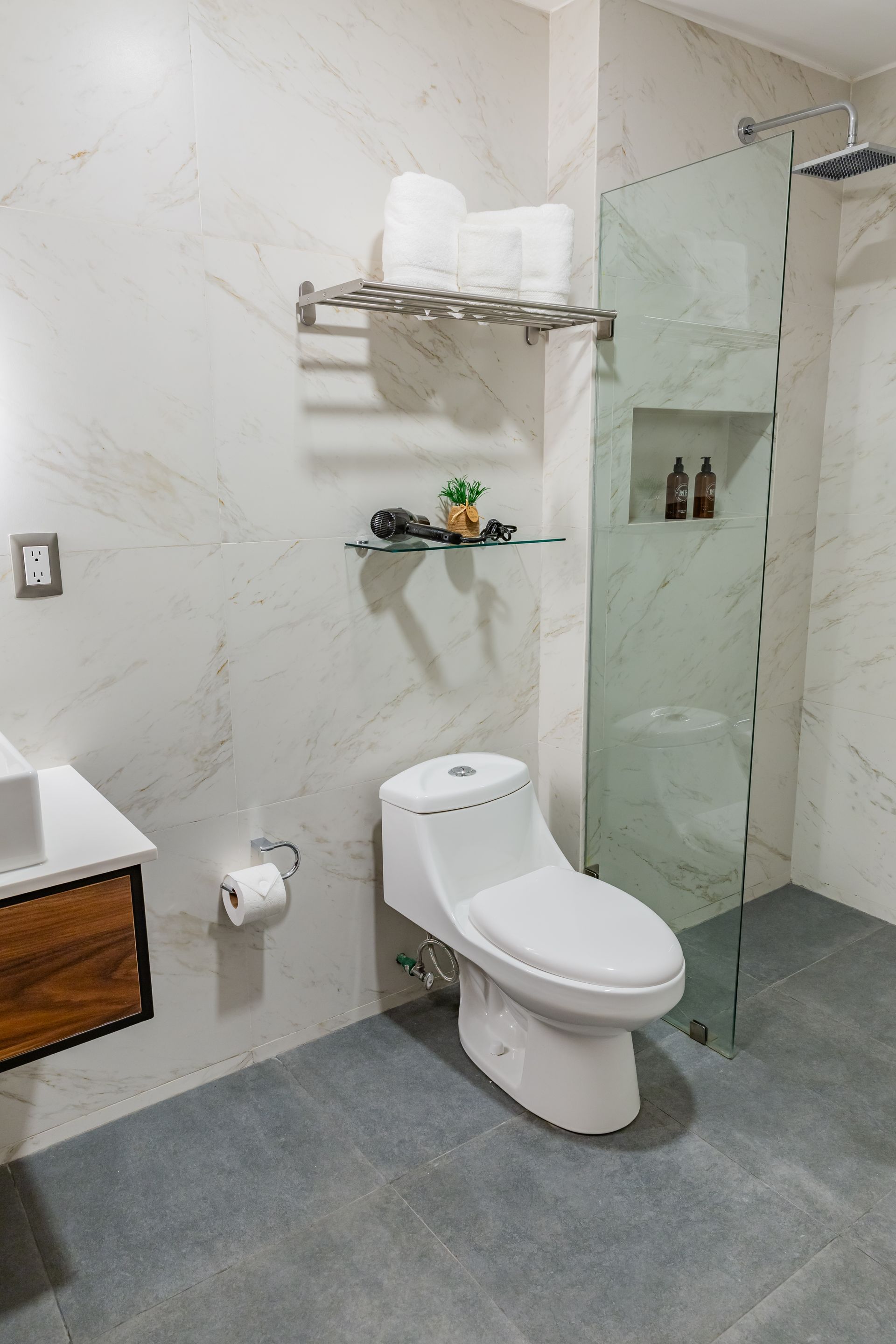 Un baño con inodoro, lavabo y ducha.