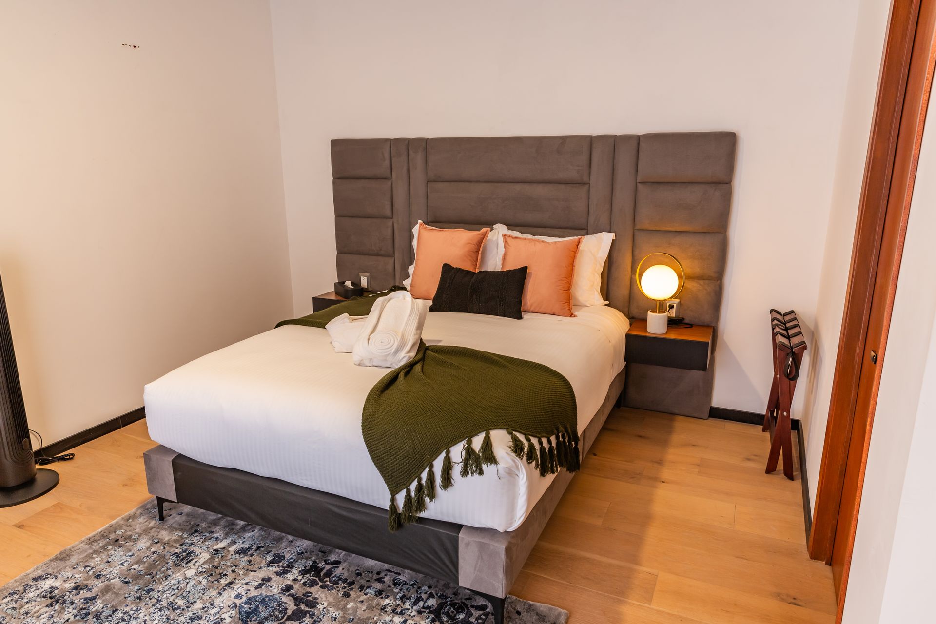 Un dormitorio con una cama grande y una alfombra en el suelo.