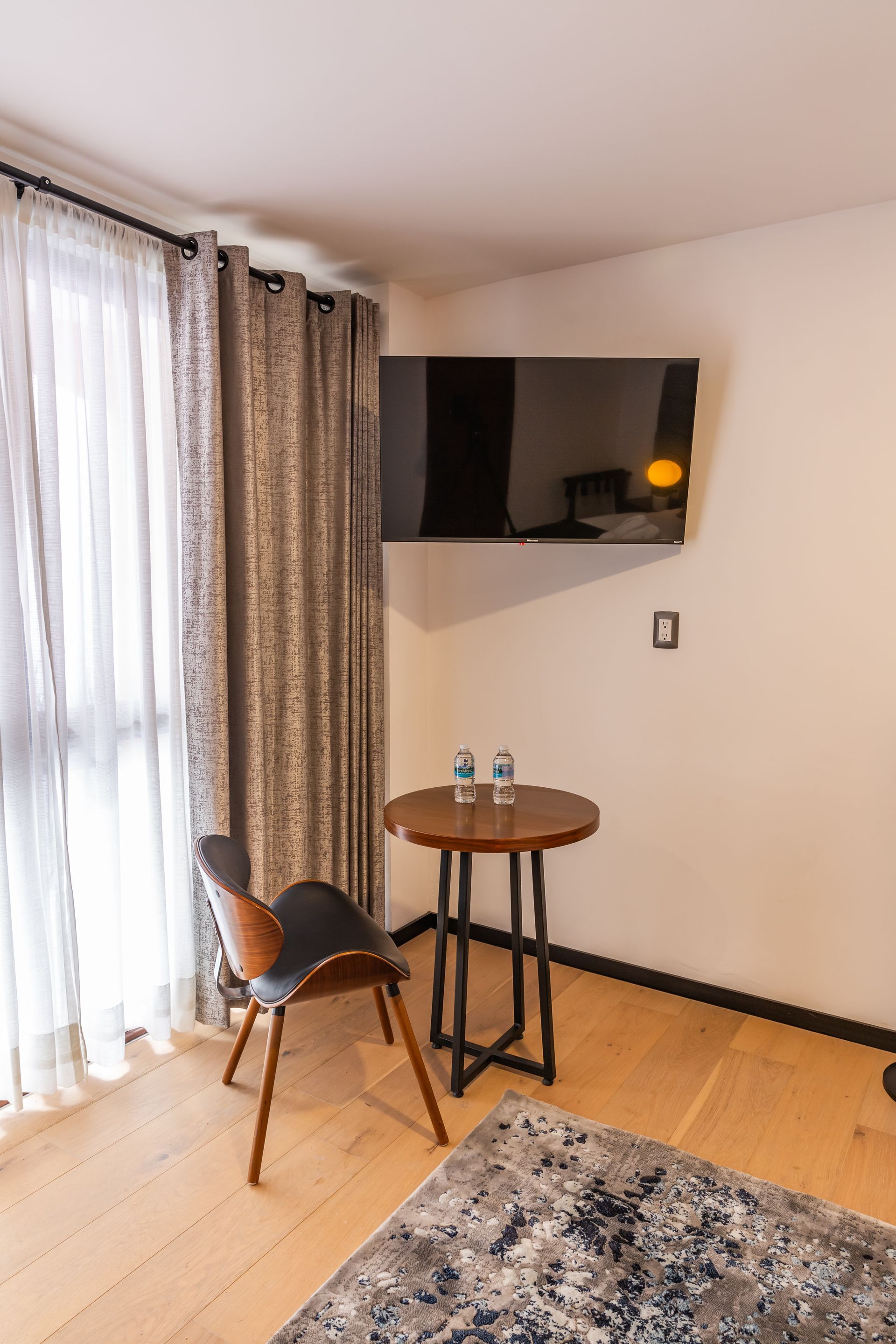 Una habitación de hotel con una mesa, una silla y una televisión.