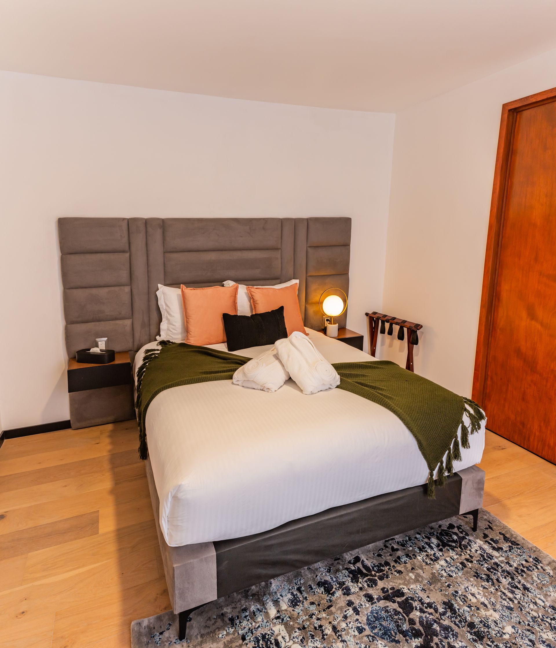 Un dormitorio con una cama king size y una alfombra.