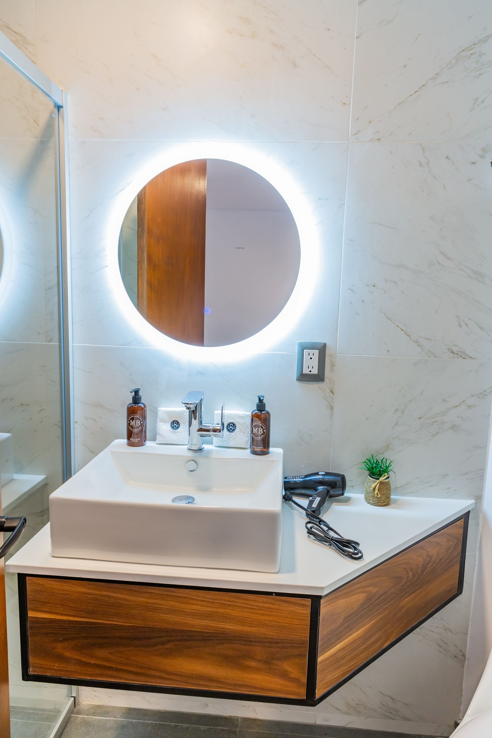 Un baño con lavabo, espejo y secador de pelo.